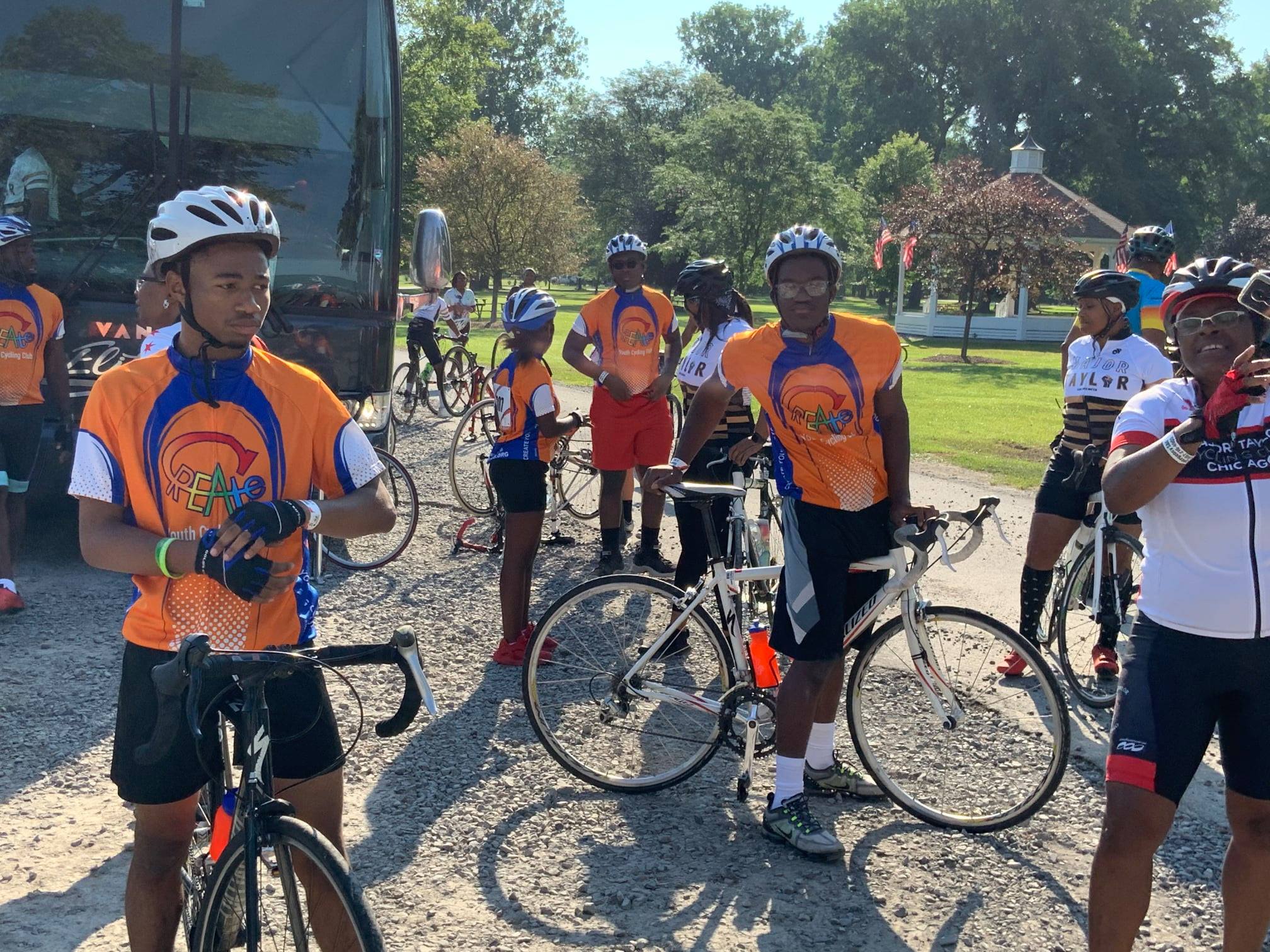 A CREATE cycling group stands wearing matching jerseys