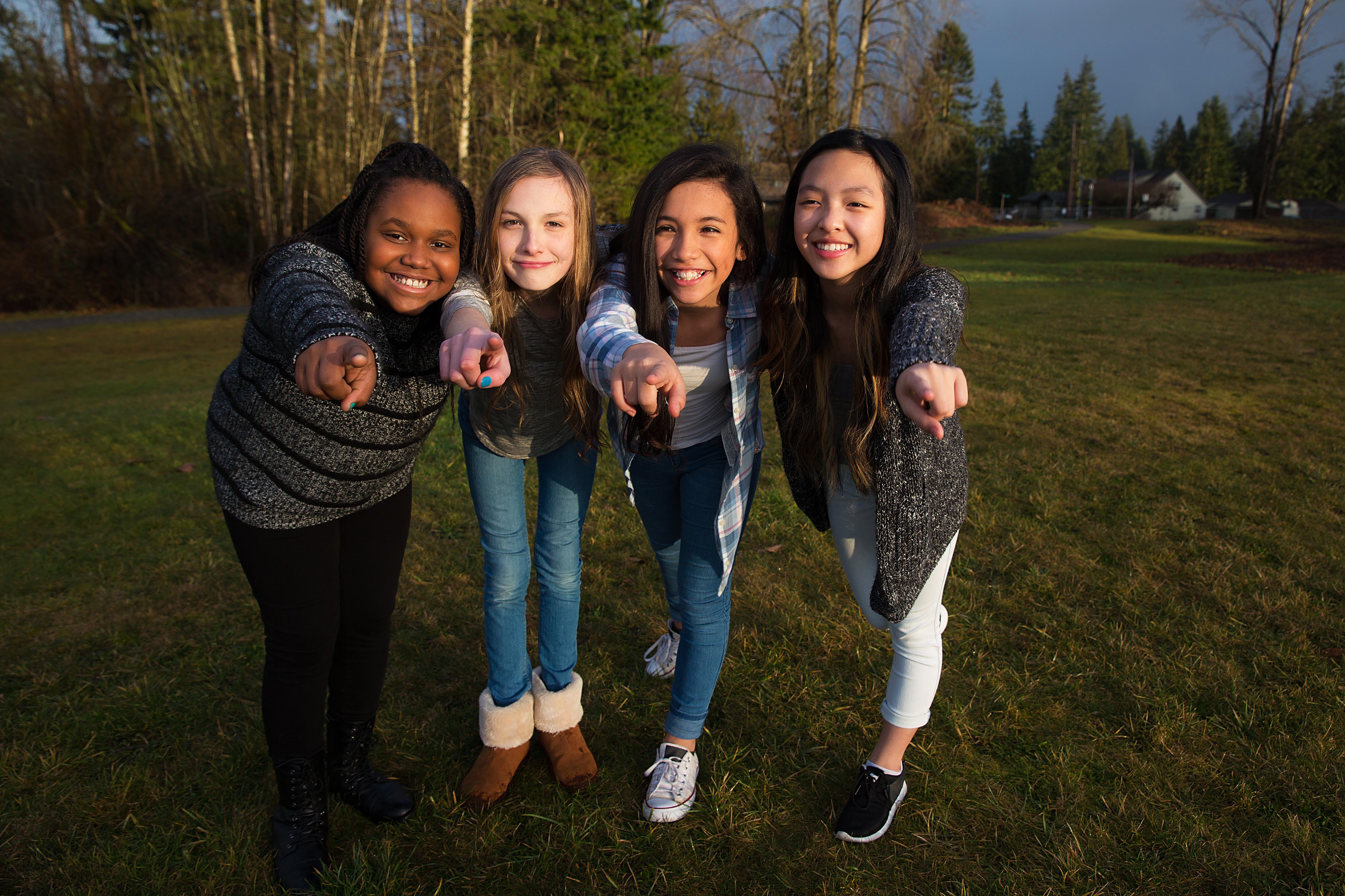 a group of young people stand together and point at the camera