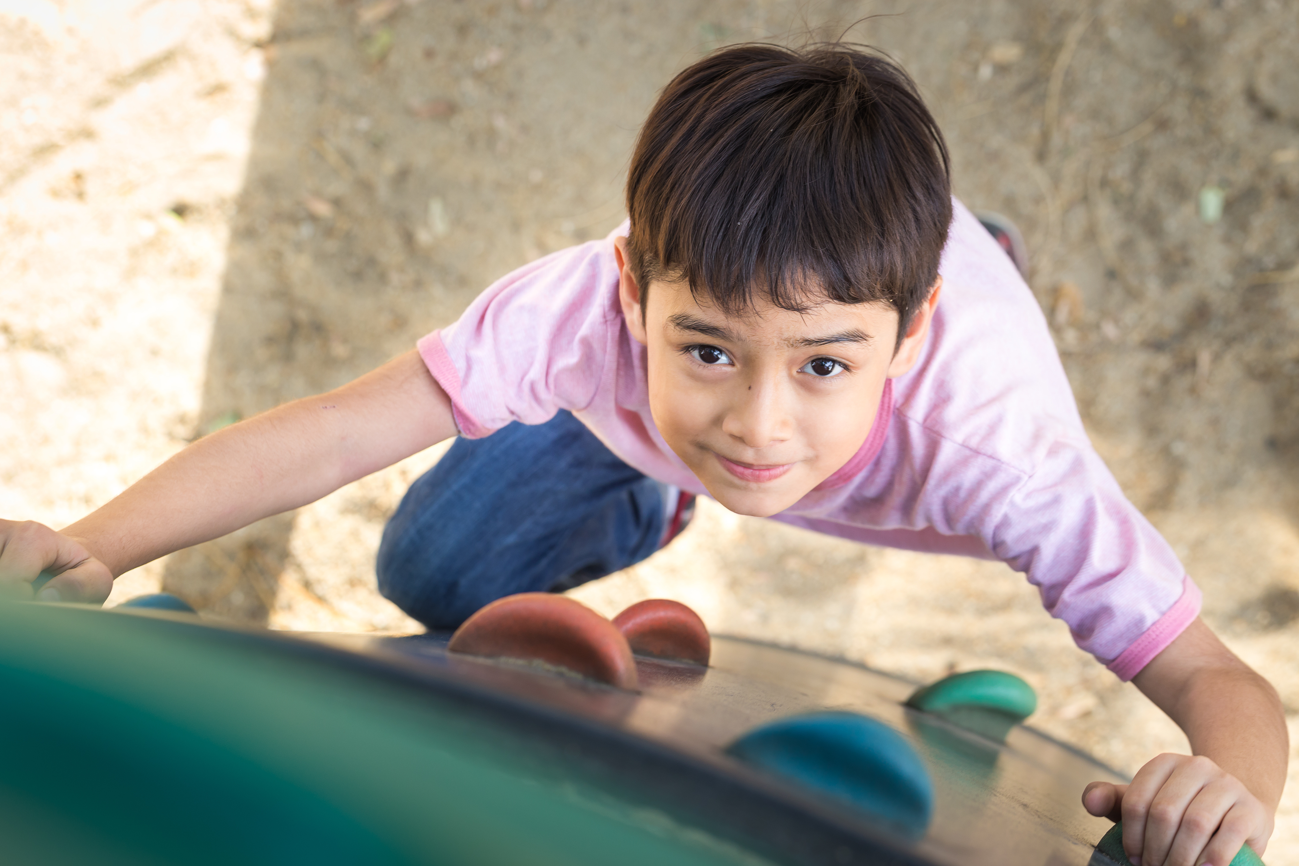 a young boy climbs on a rock wall