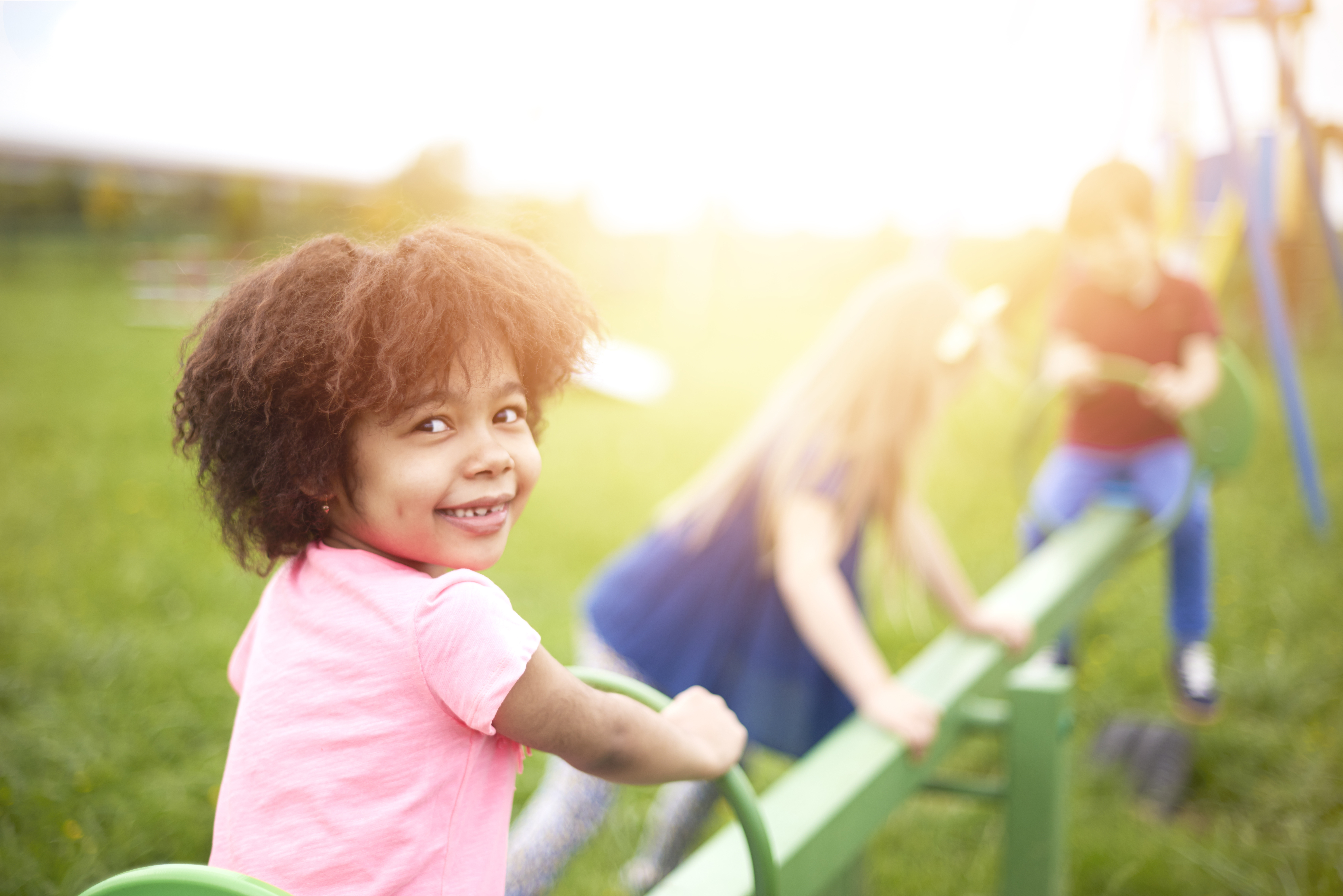 a girl rides a seesaw in a park