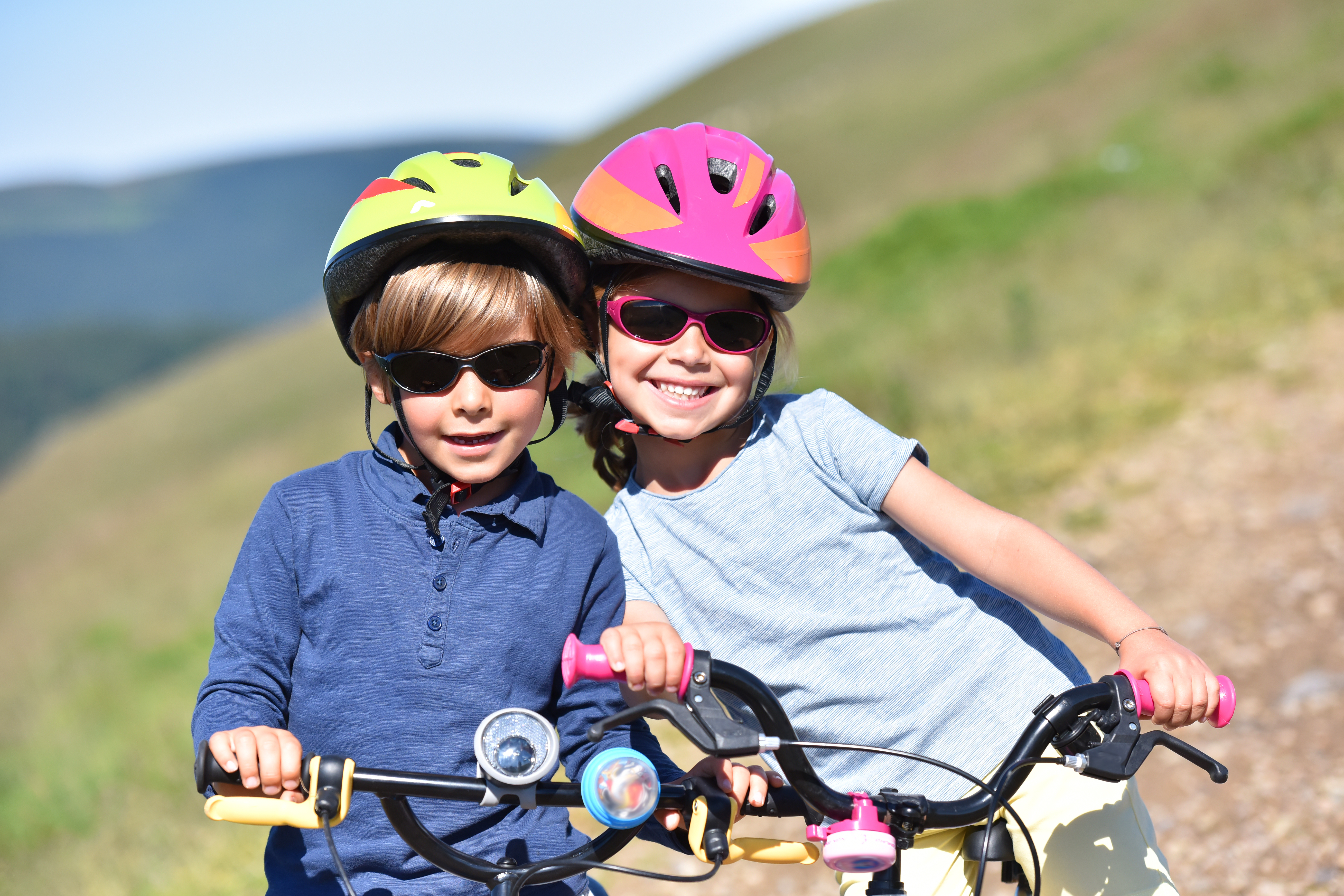 two children ride bikes in sunglasses