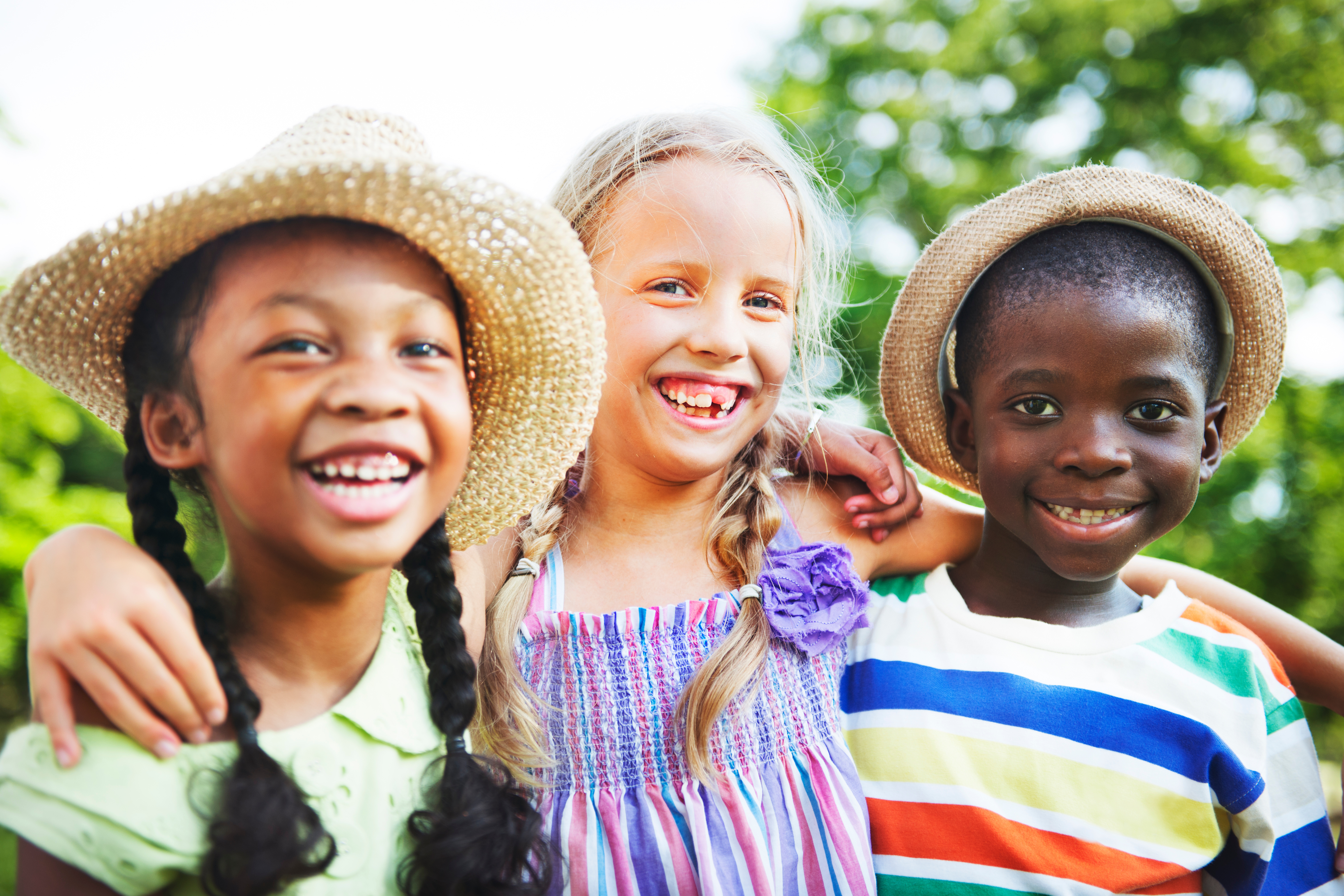 a group of kids smiles under some trees