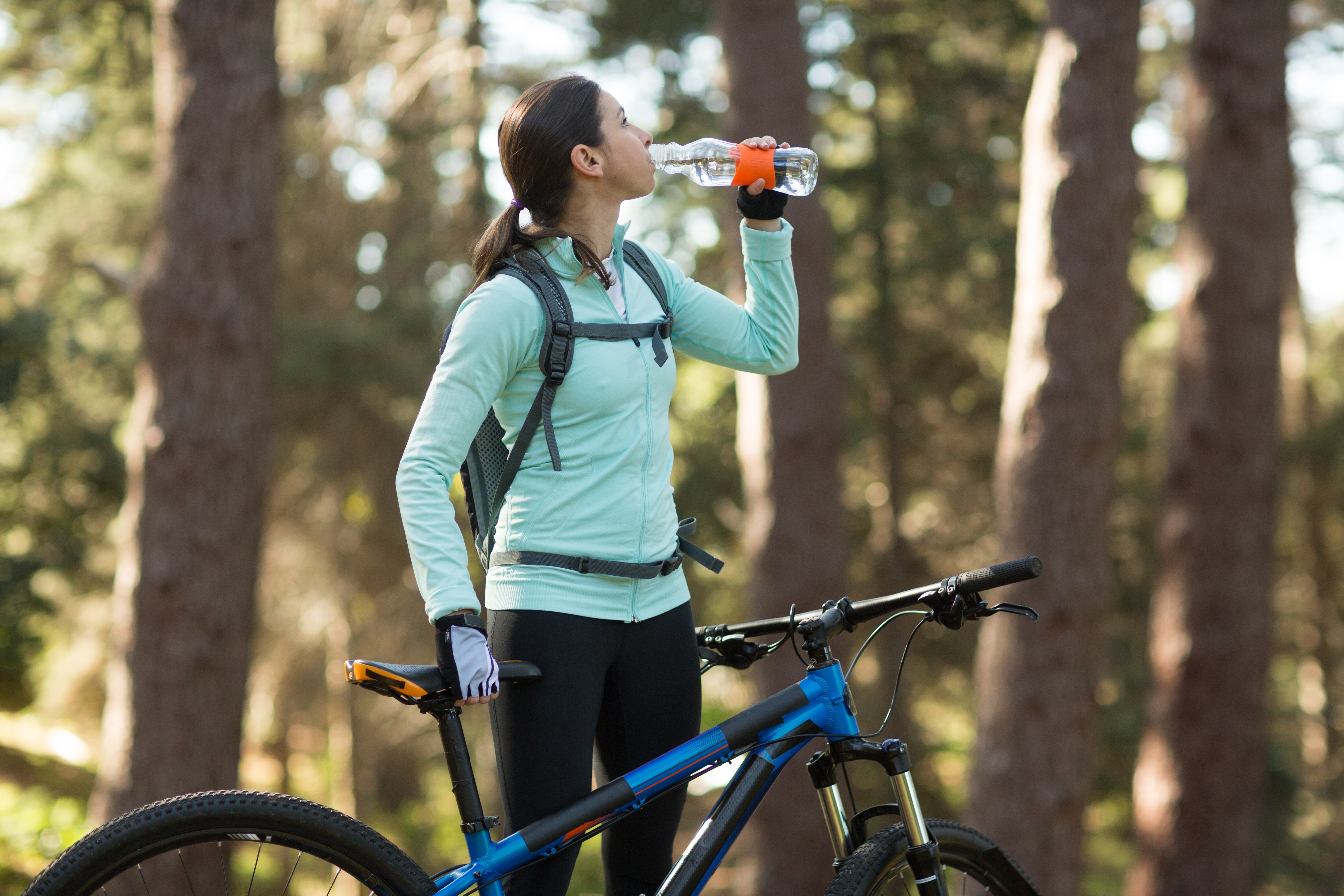 woman hydrating while riding her bike