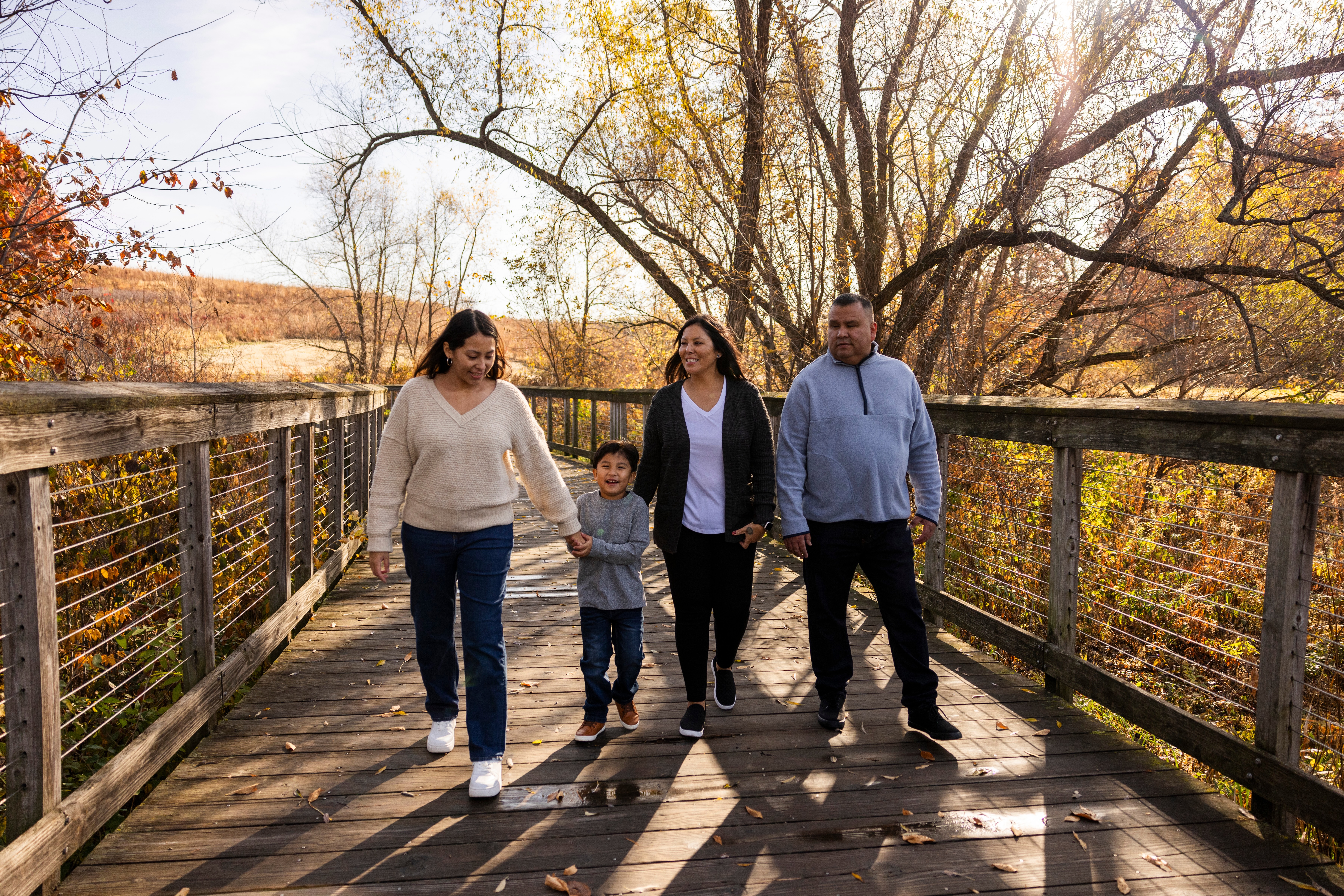 A family walks on a bridge in a park