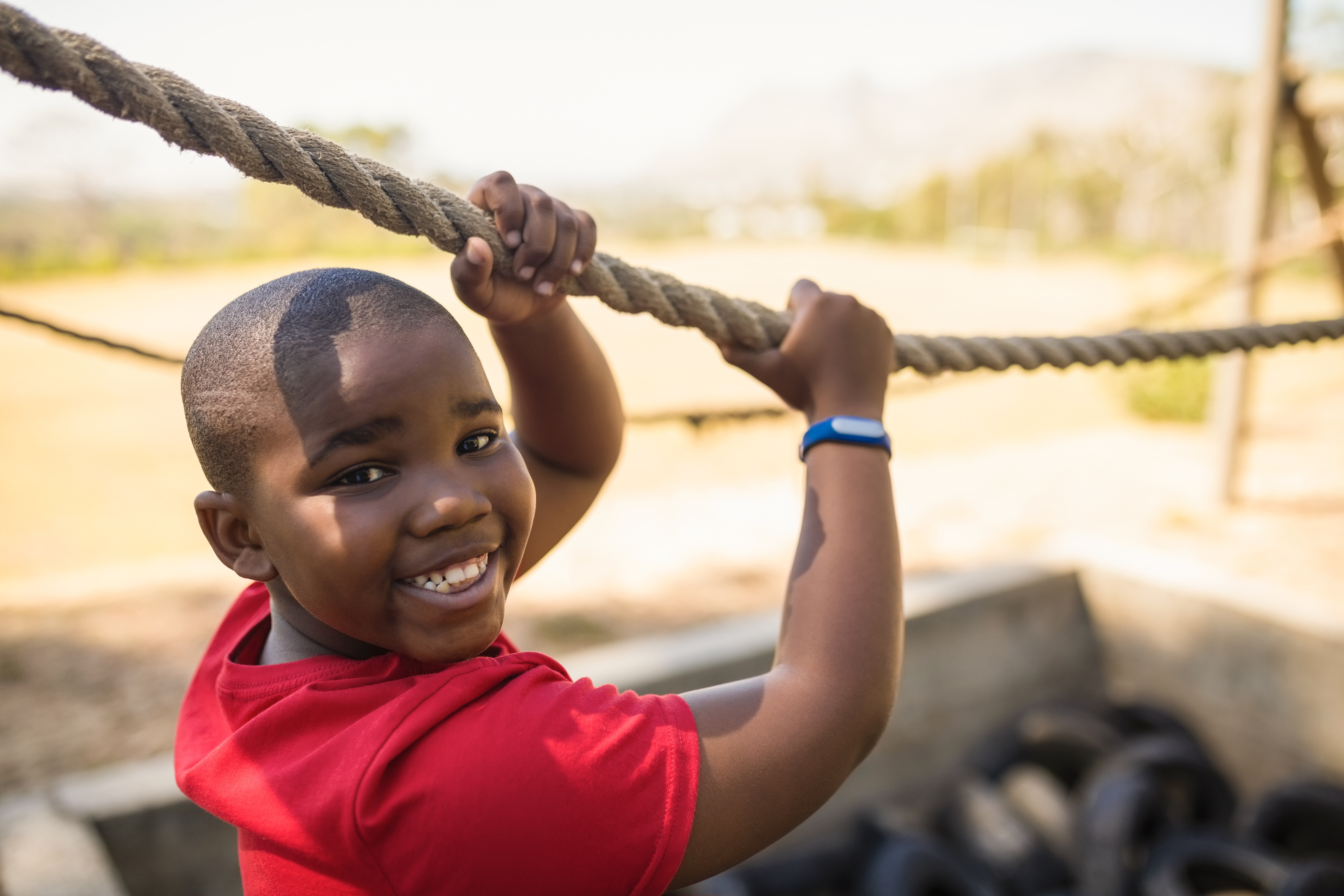 young boy using a rope to complete an element