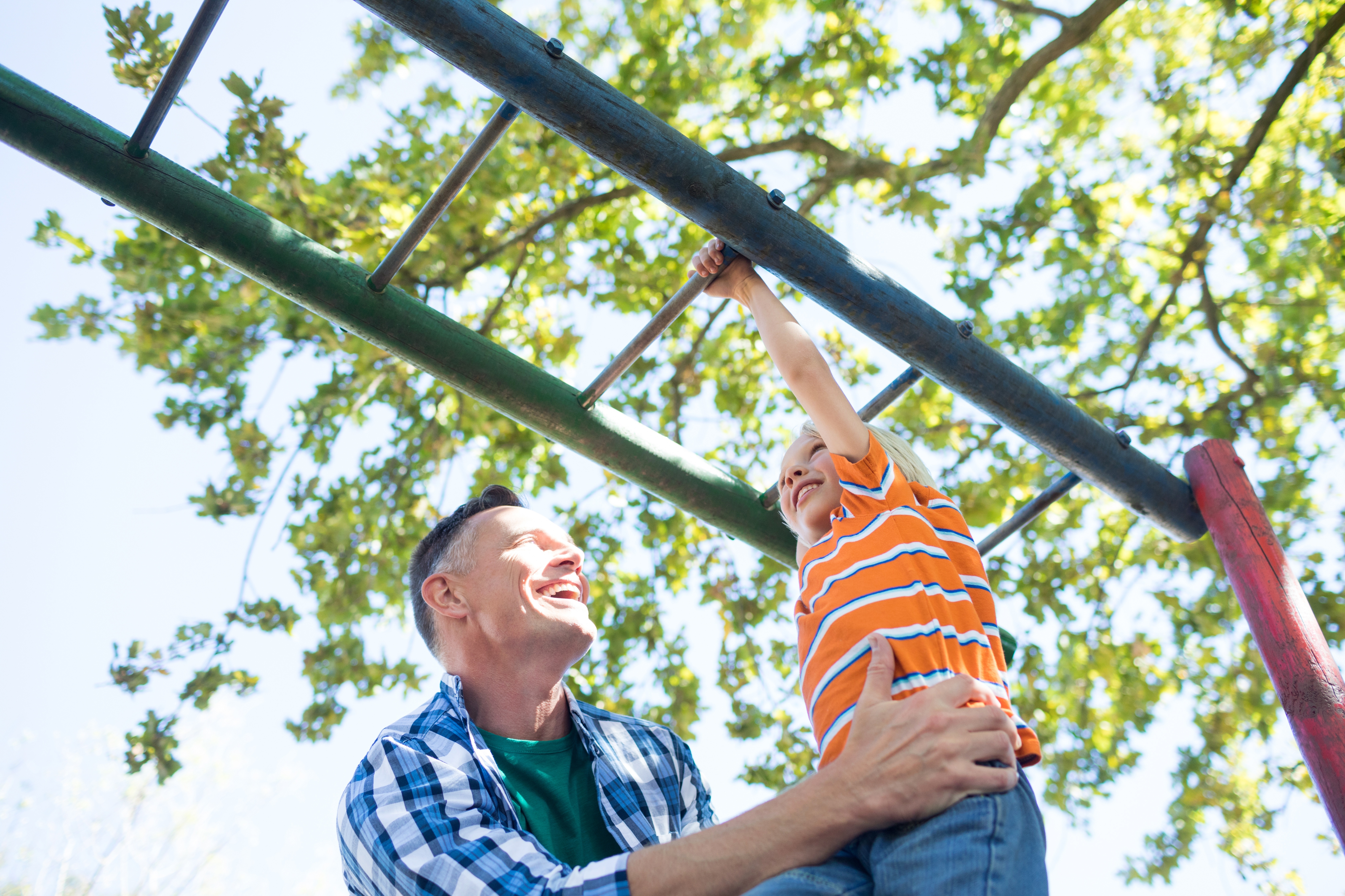 parent helping a child on the monkey bars