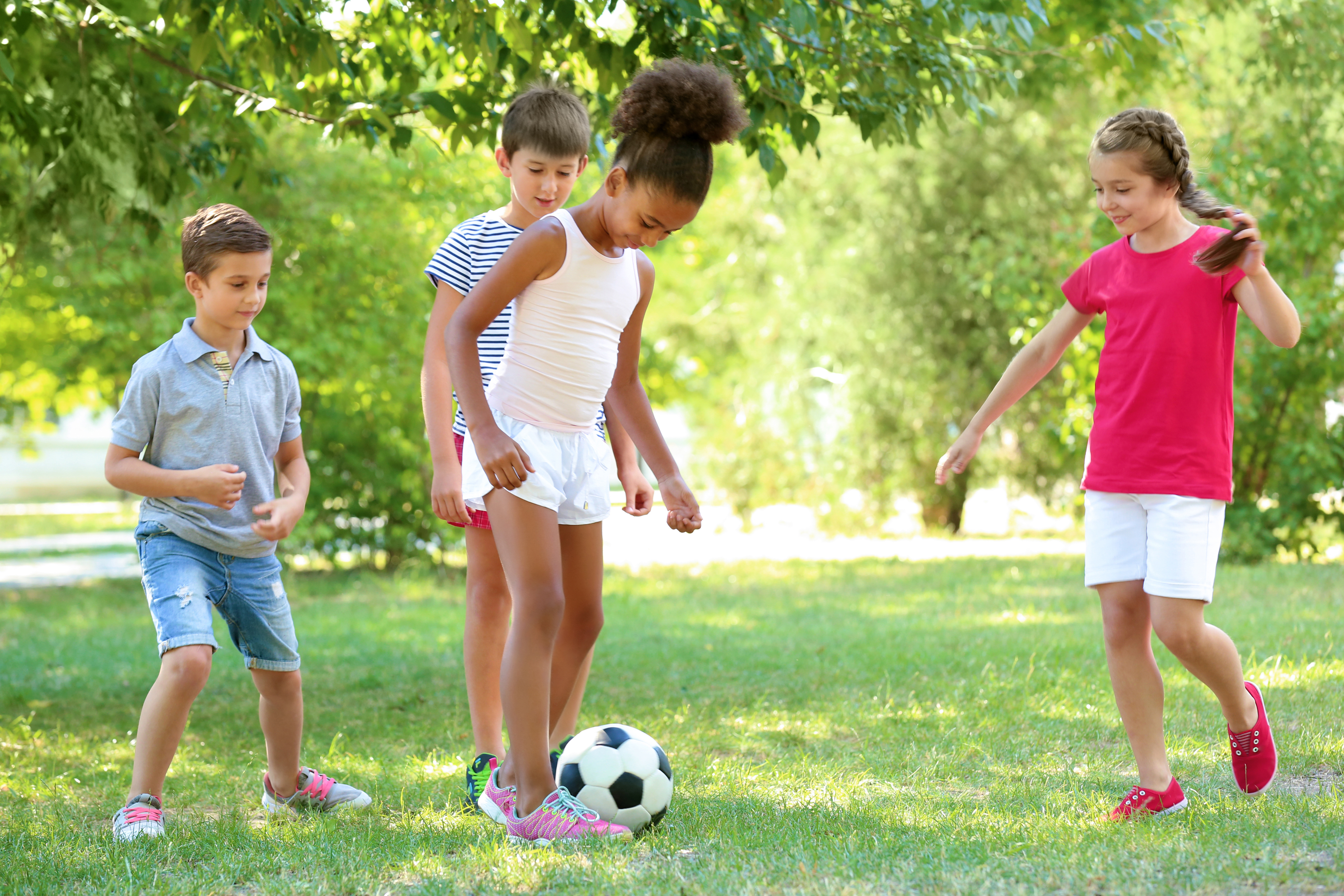 kids play with a soccer ball in the park