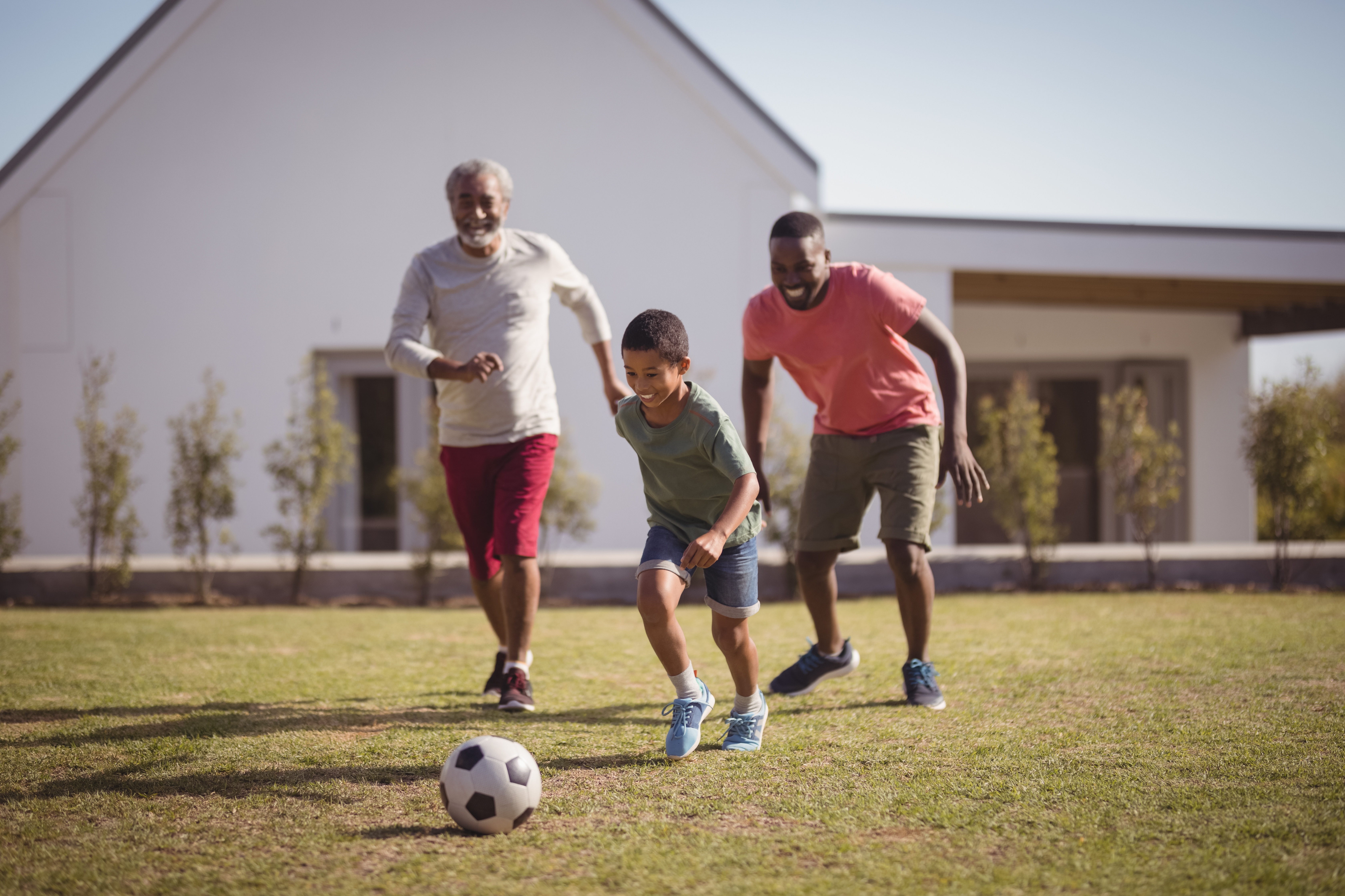 father, son, and grandfather playing soccer