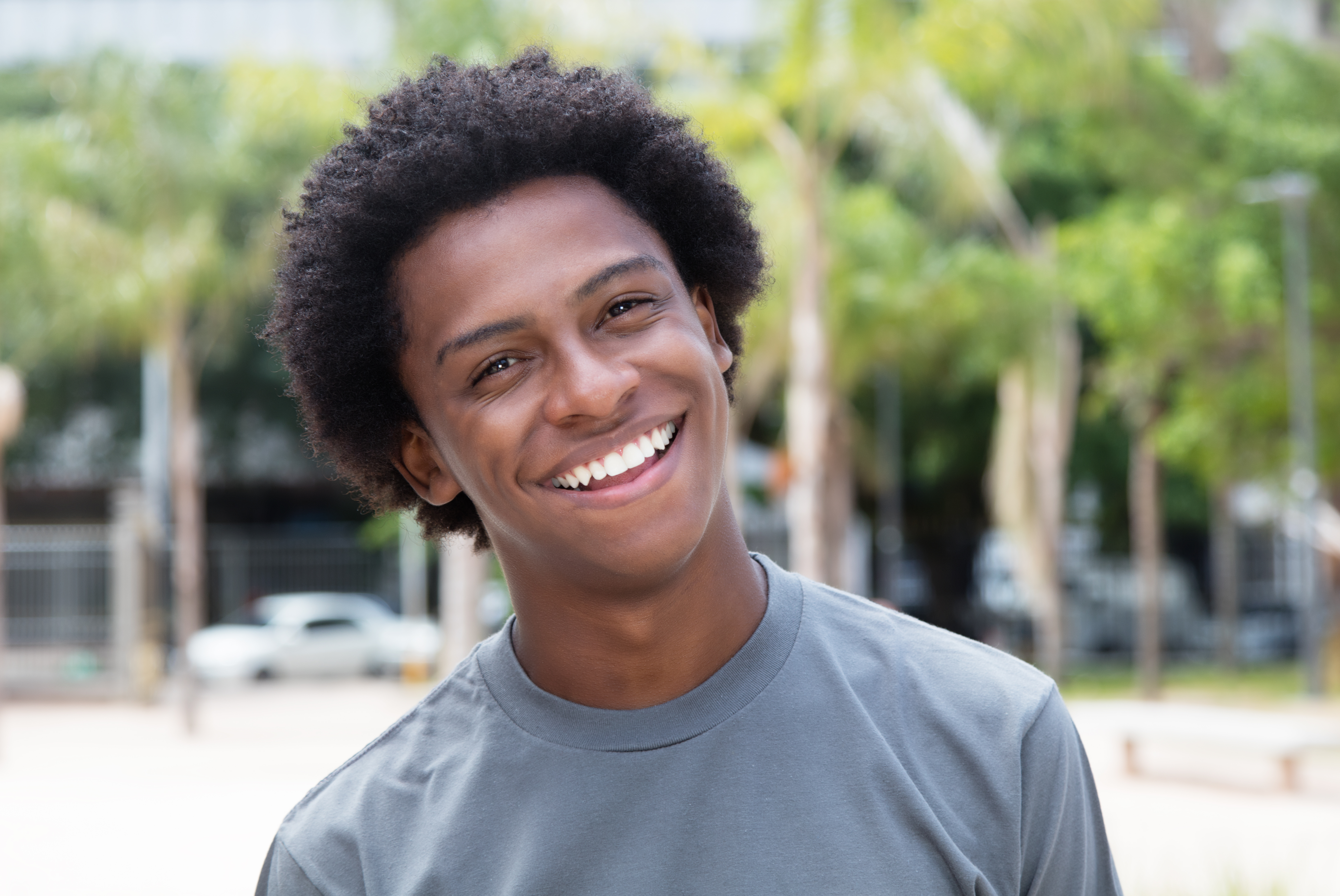 a teenage boy smiles in a park