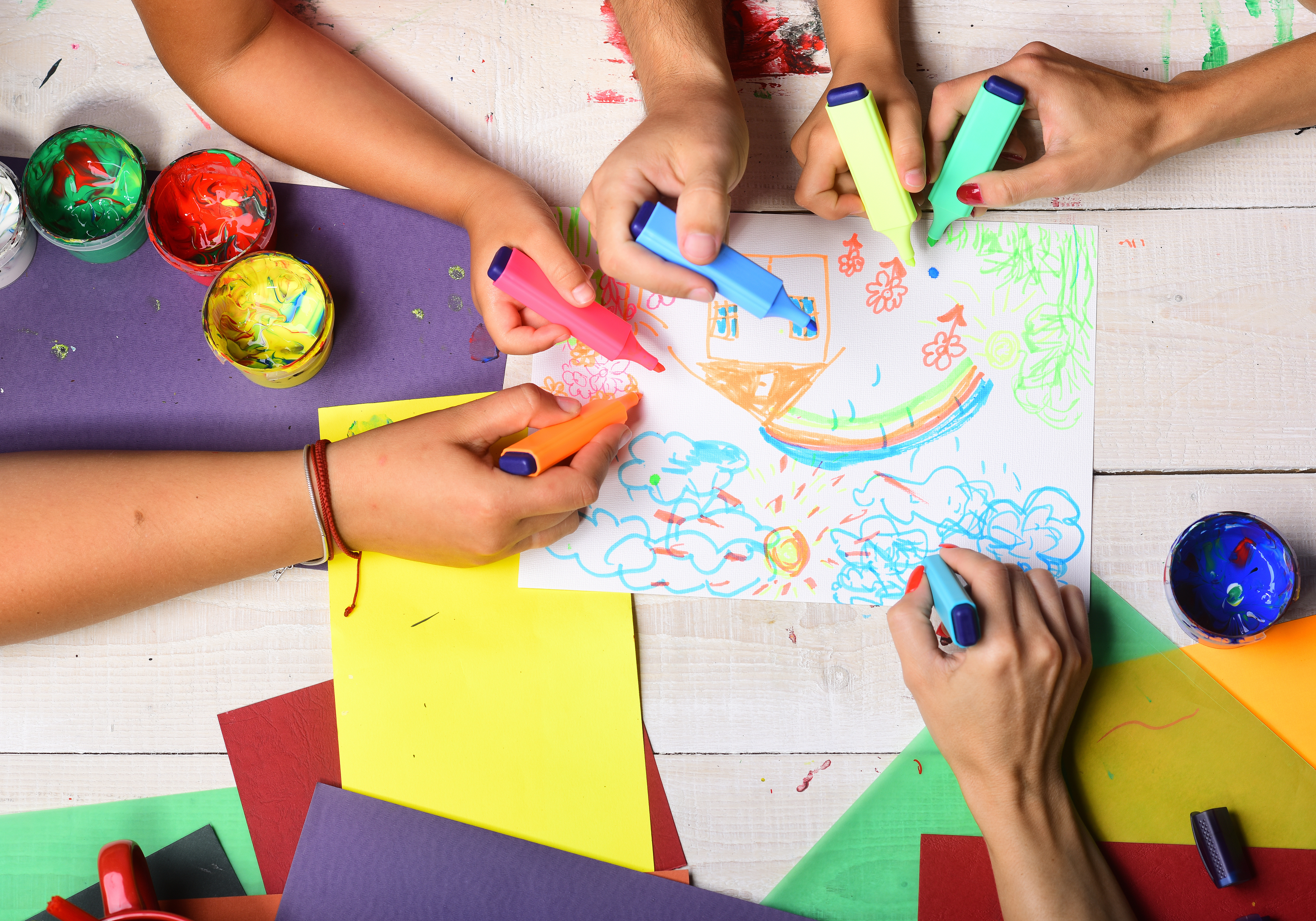 Many hands work together to draw a picture