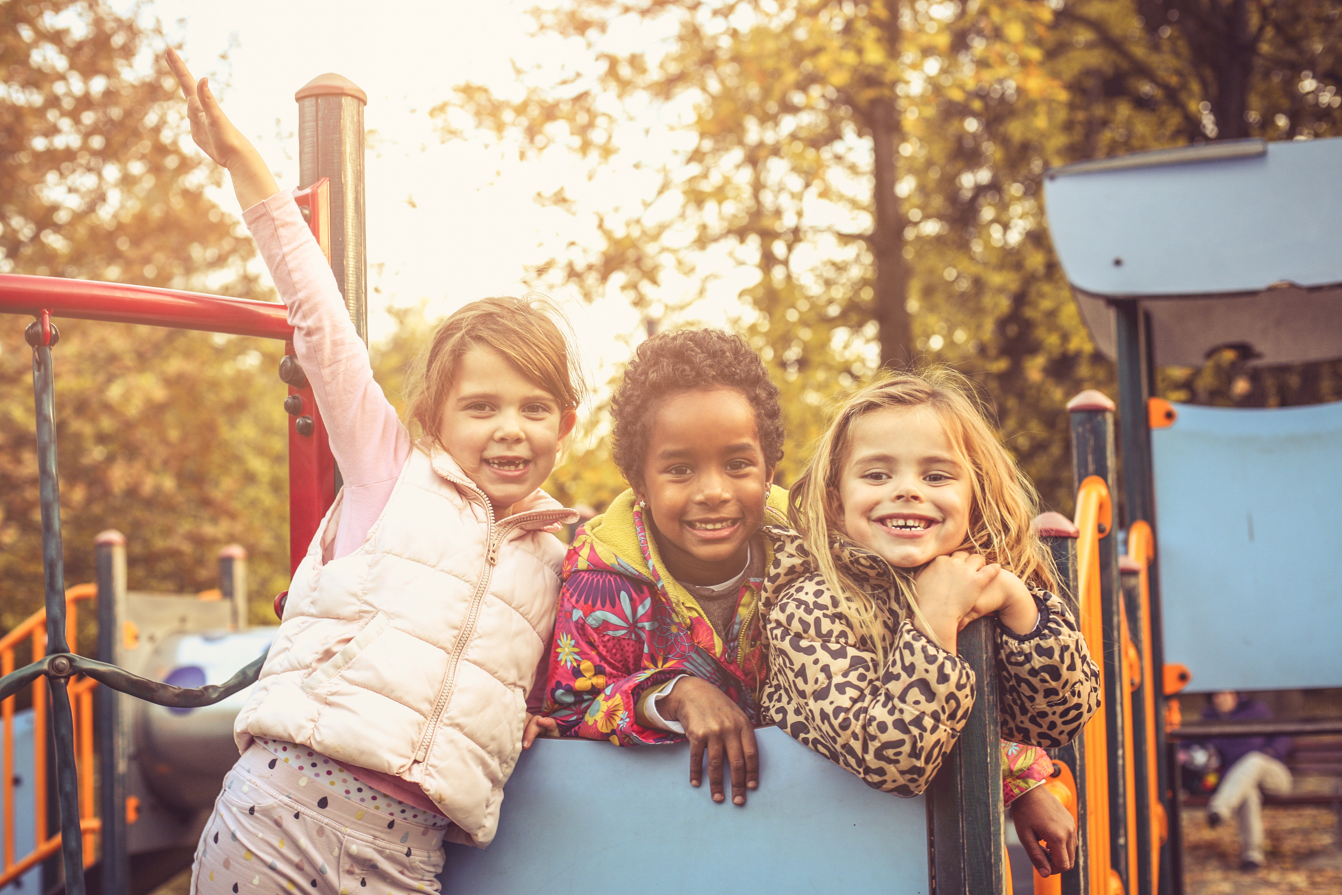 three young kids on a playground