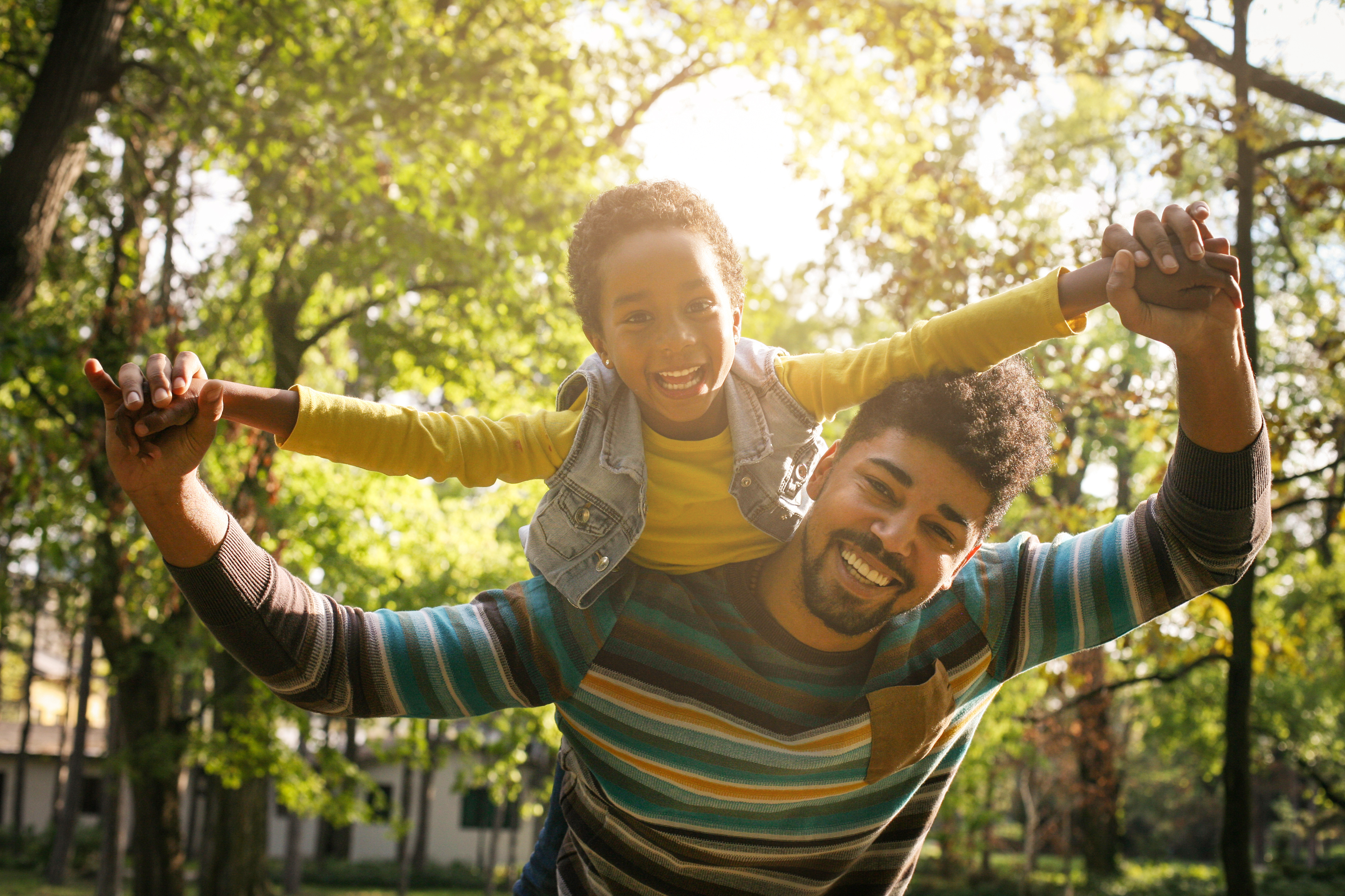 A child sits on an adult's shoulders