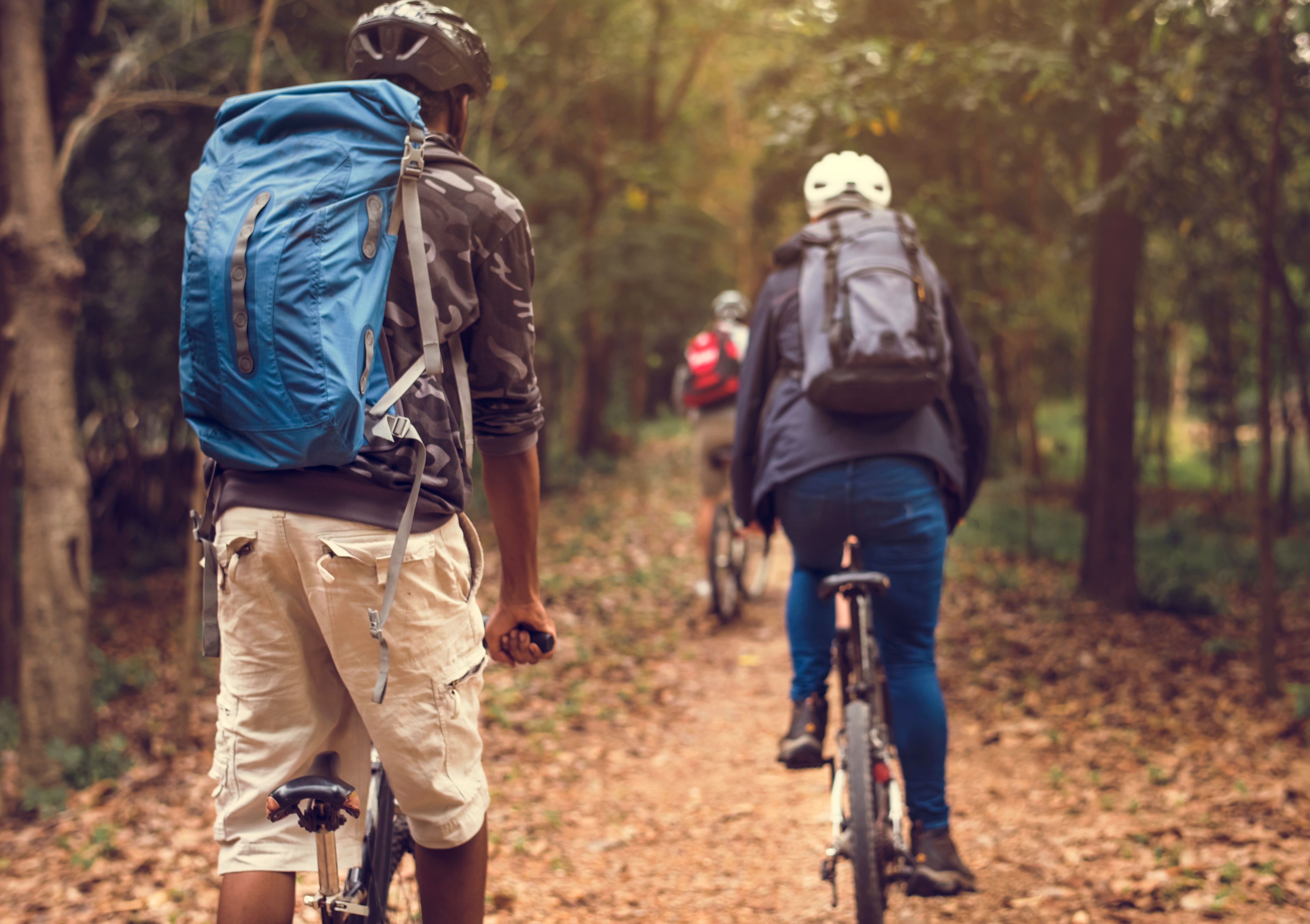 a group of young people ride their bikes on a trail