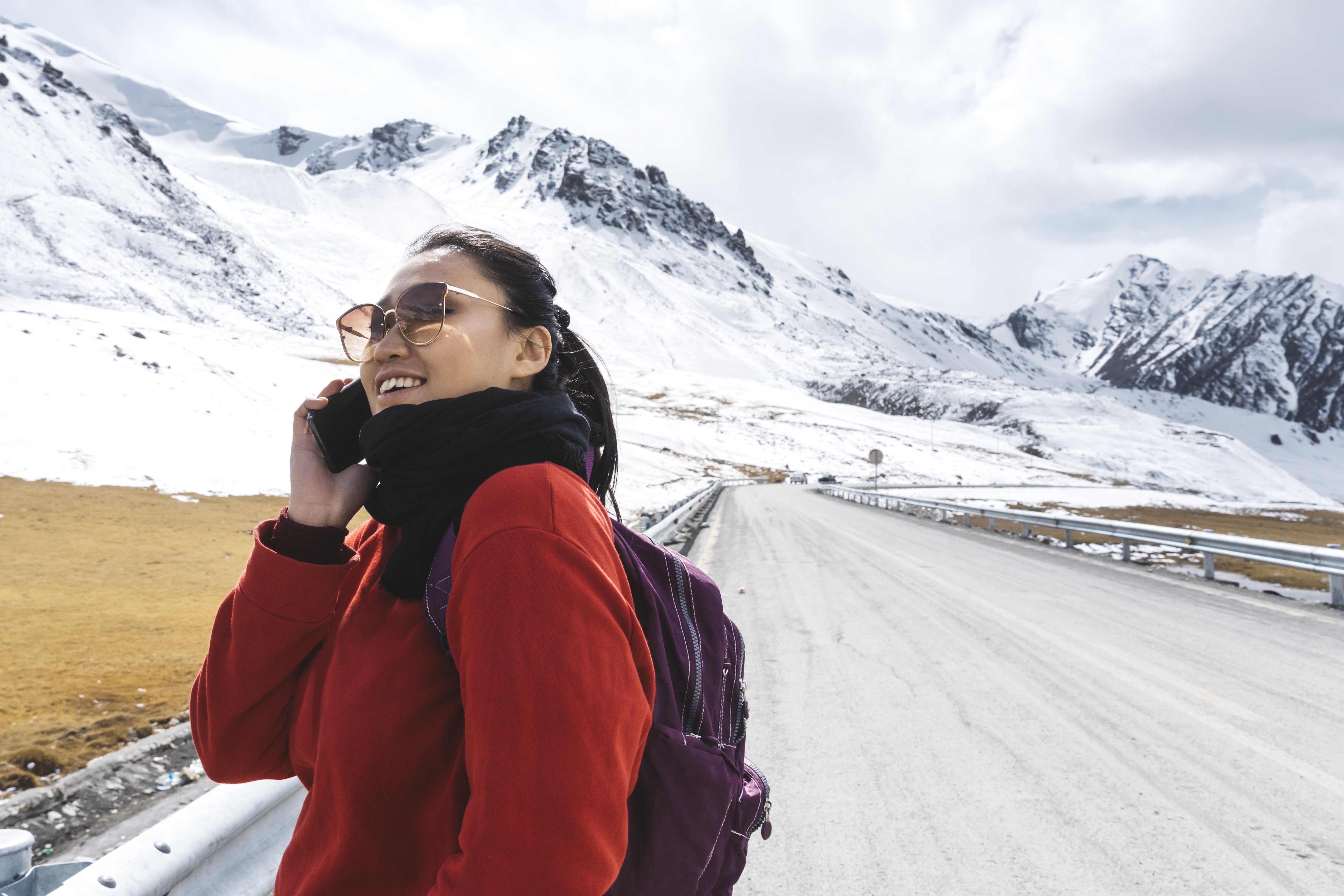 woman on cell phone in front of a mountain