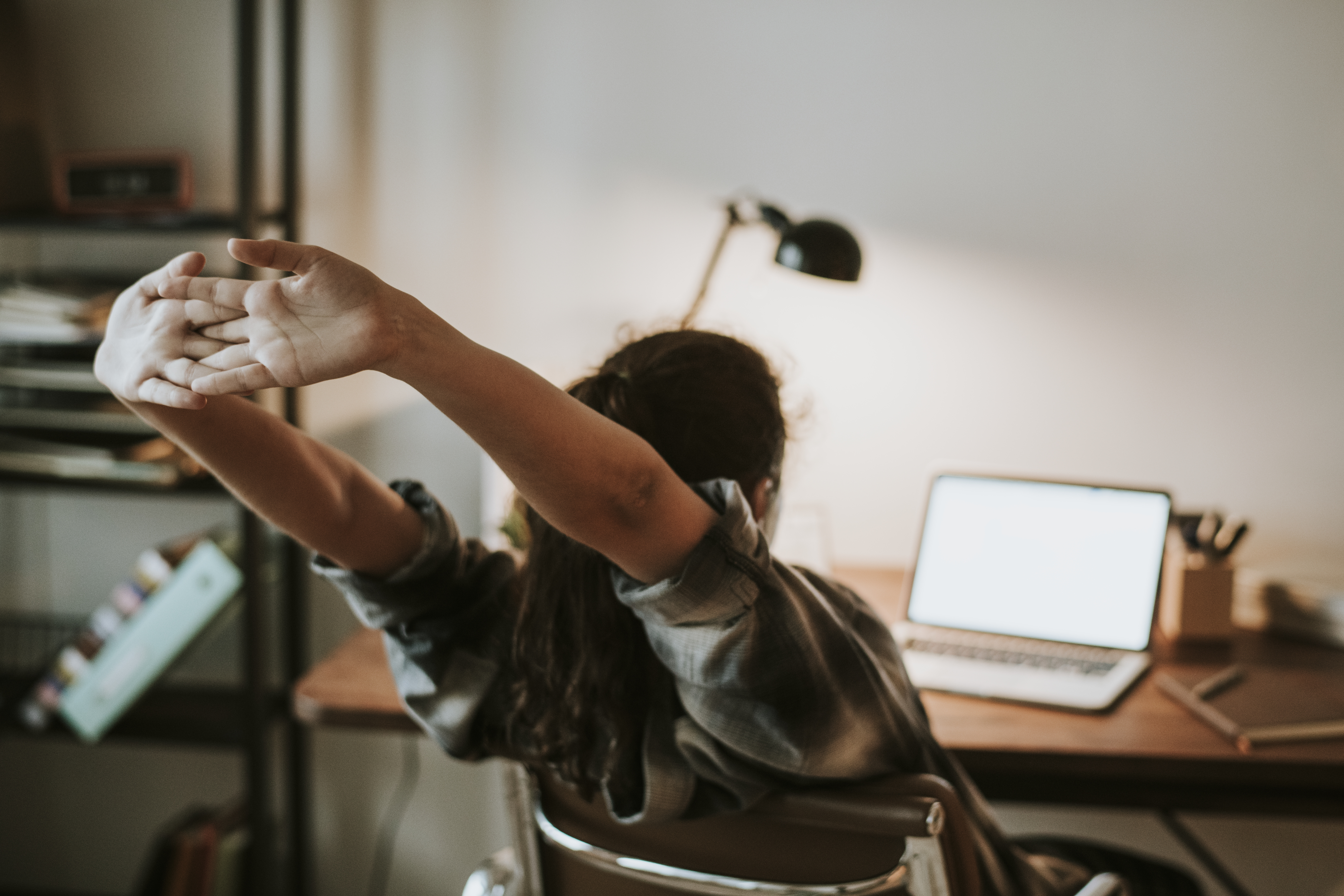 girl stretching in front of a computer