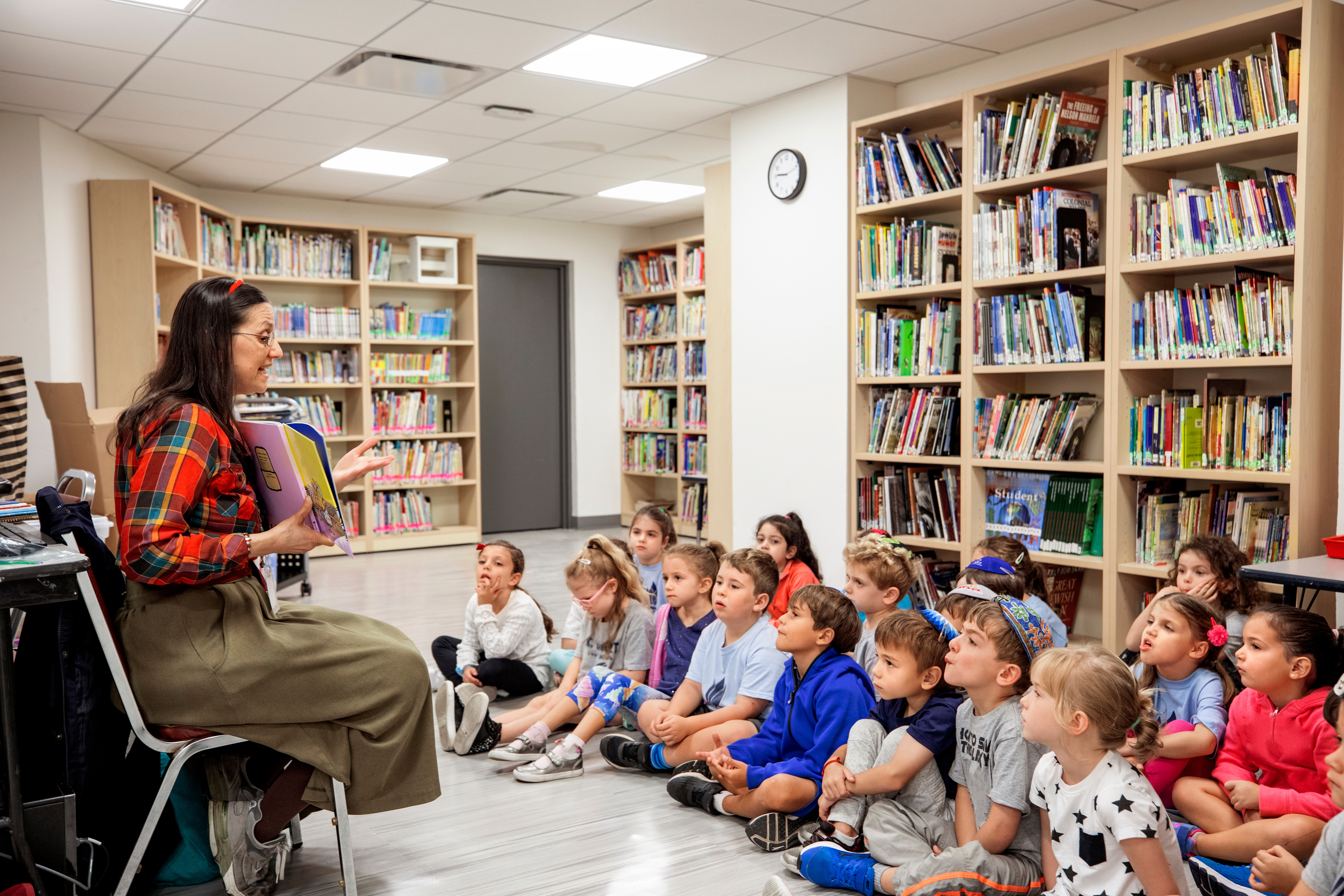 An adult reads to a group of students