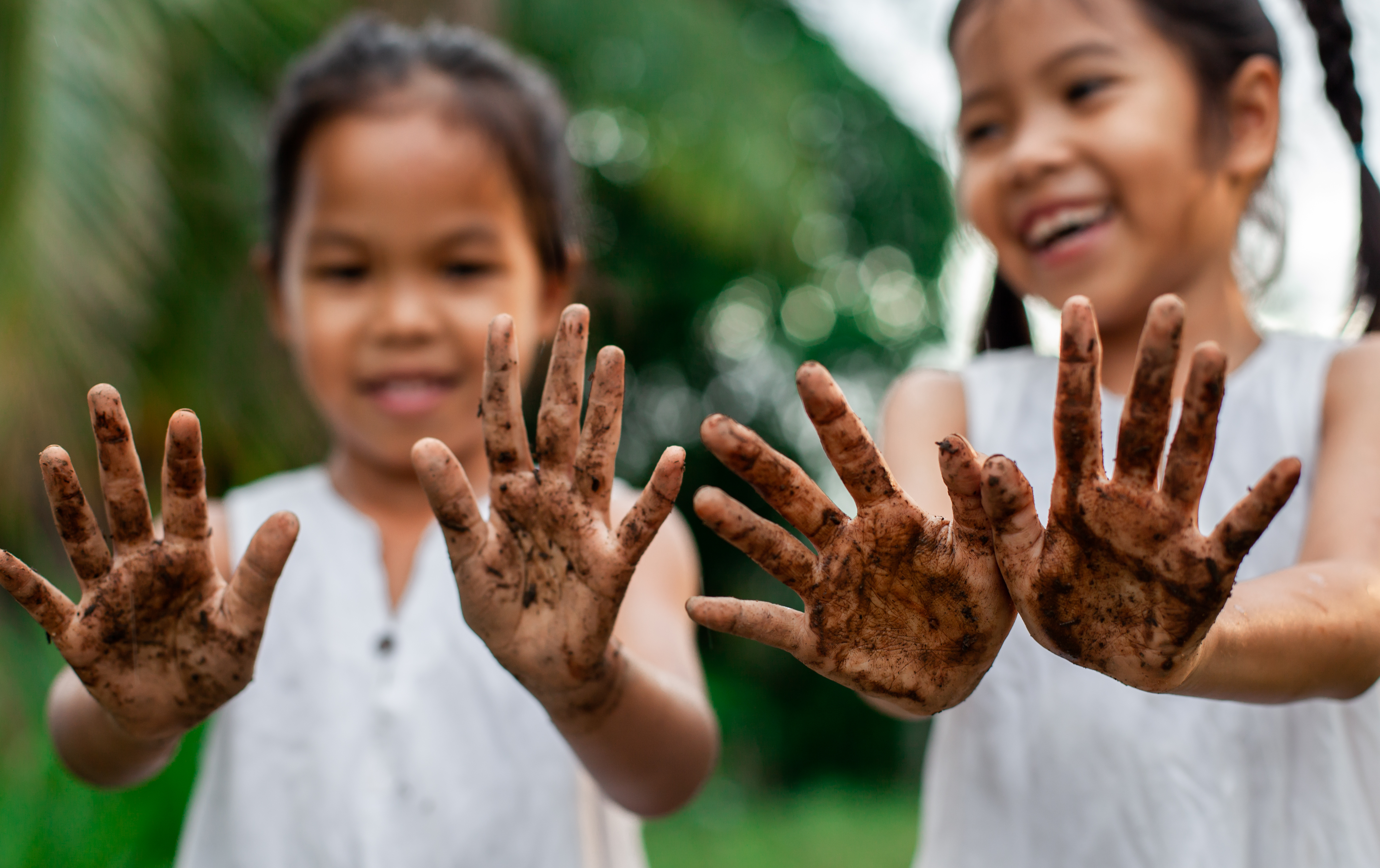 girls hold out dirt covered hands