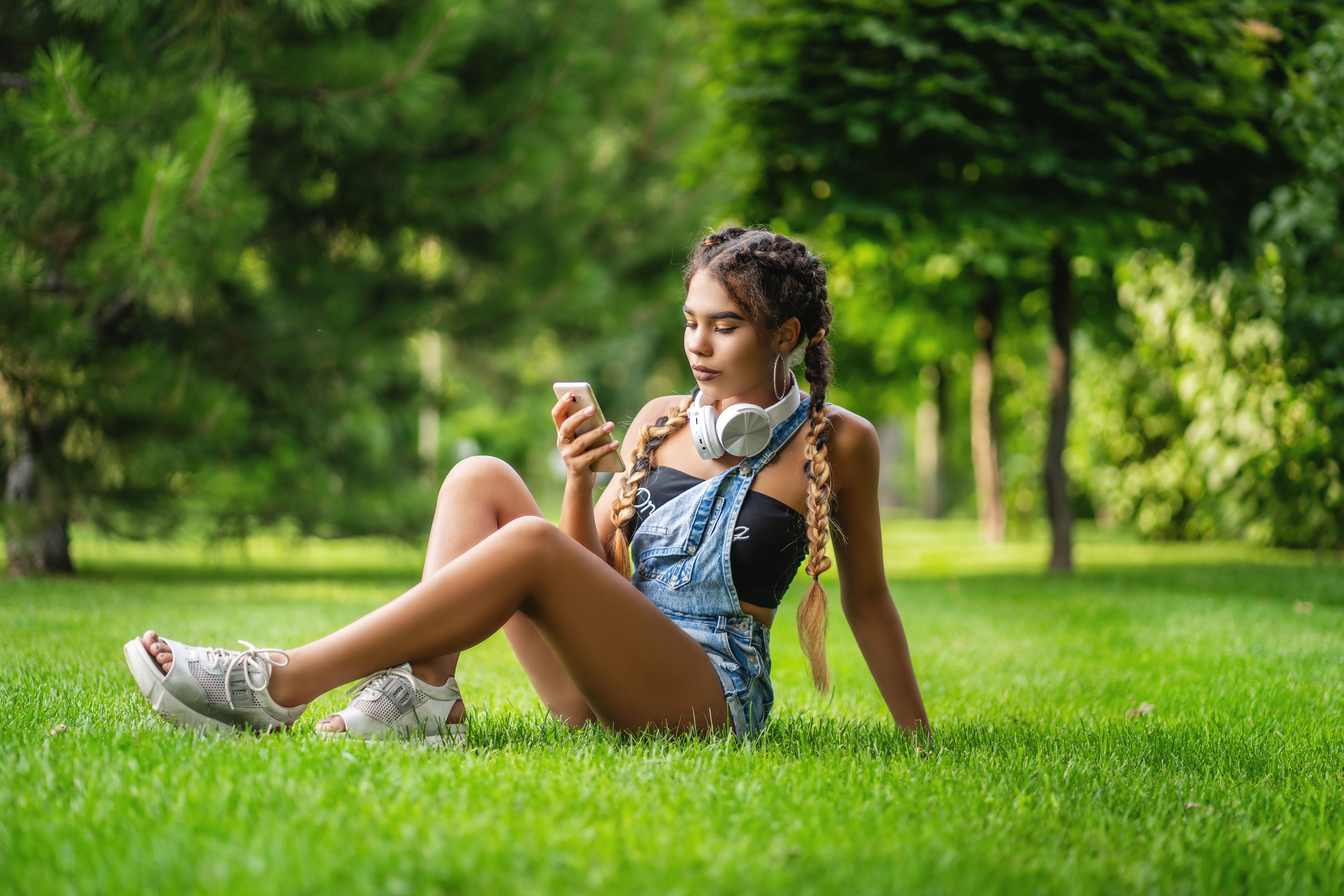 teenage girl sits in grass surrounded by trees