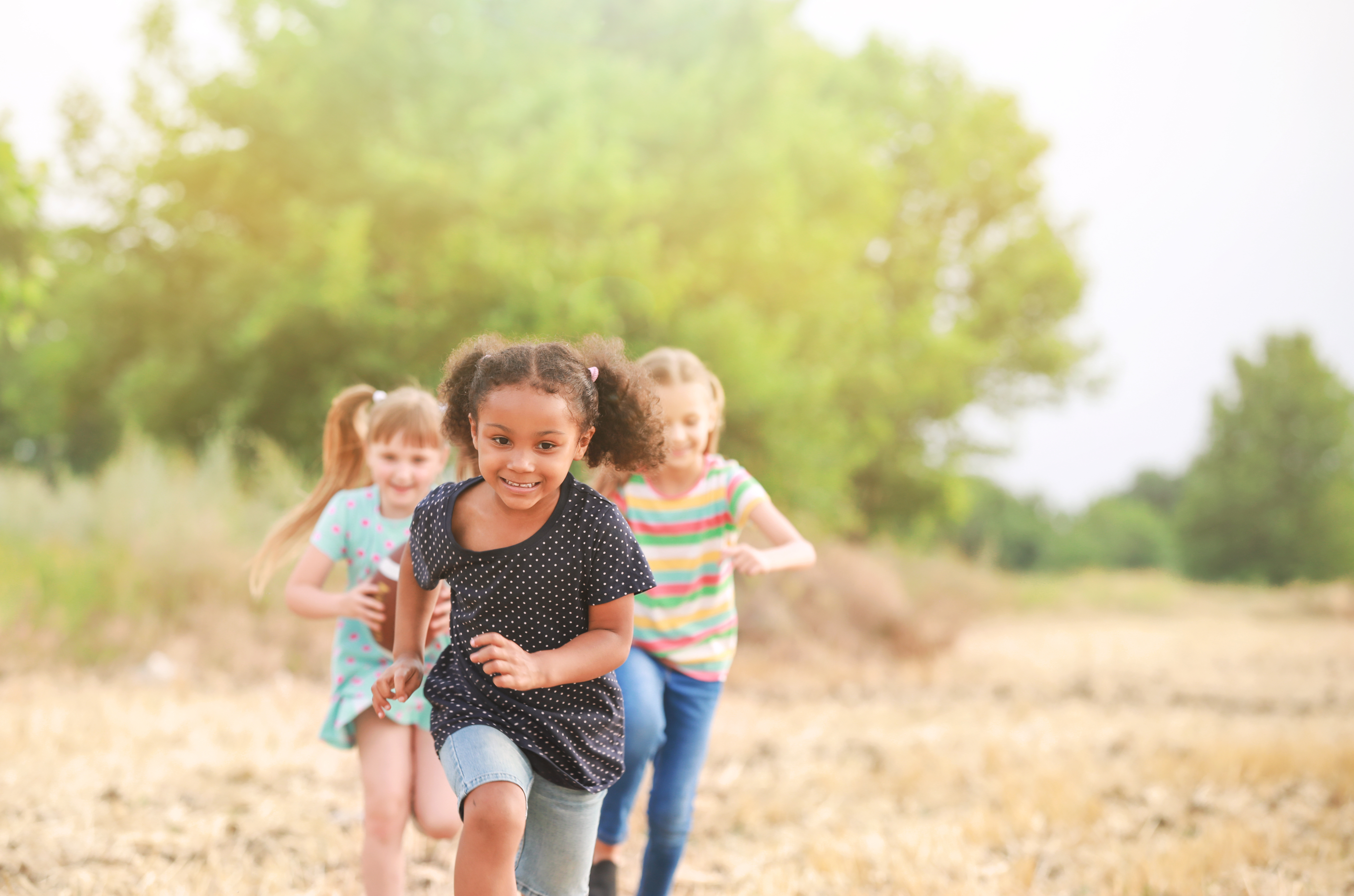 Kids run towards the camera while smiling