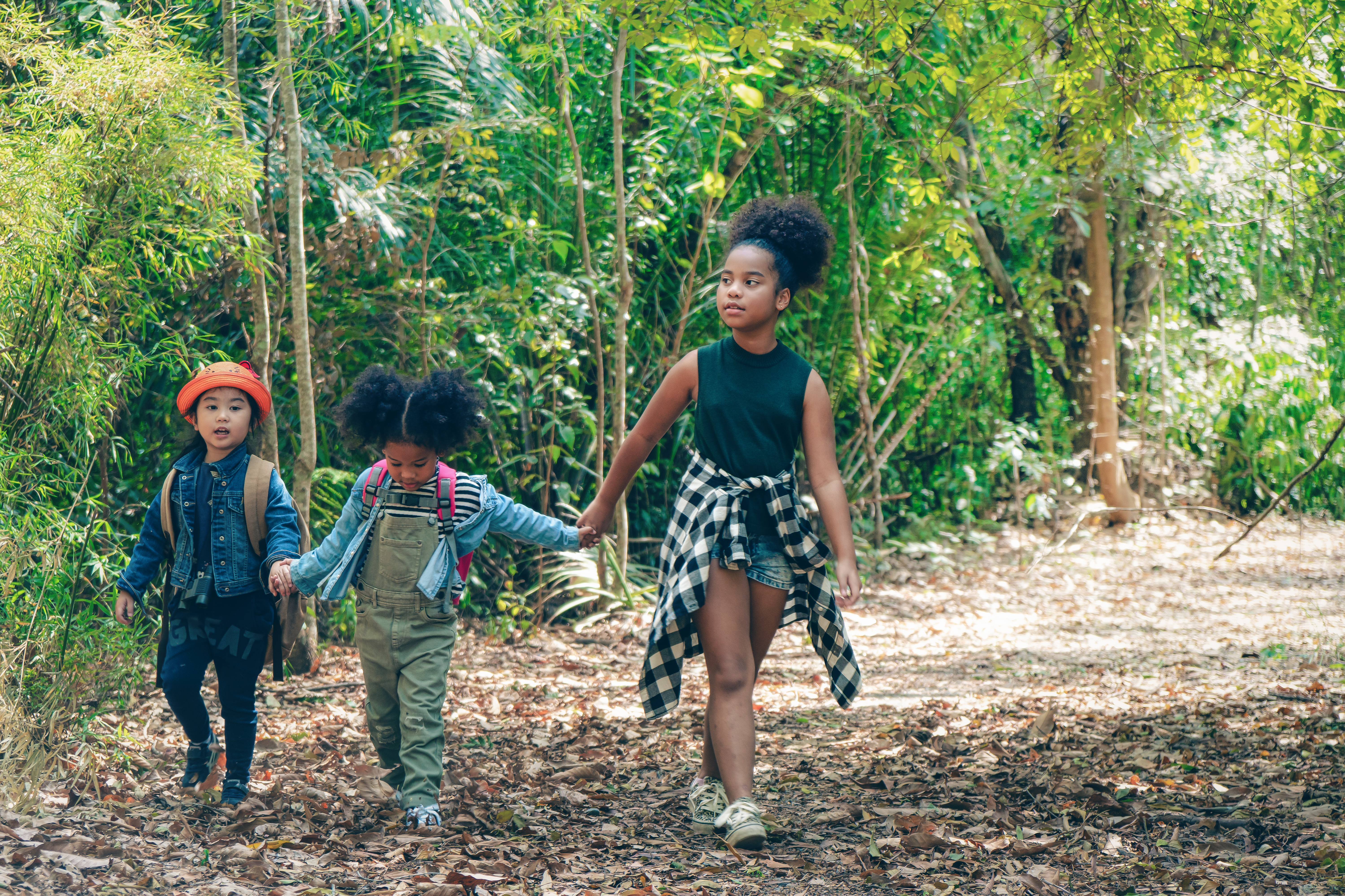 three kids playing in the woods