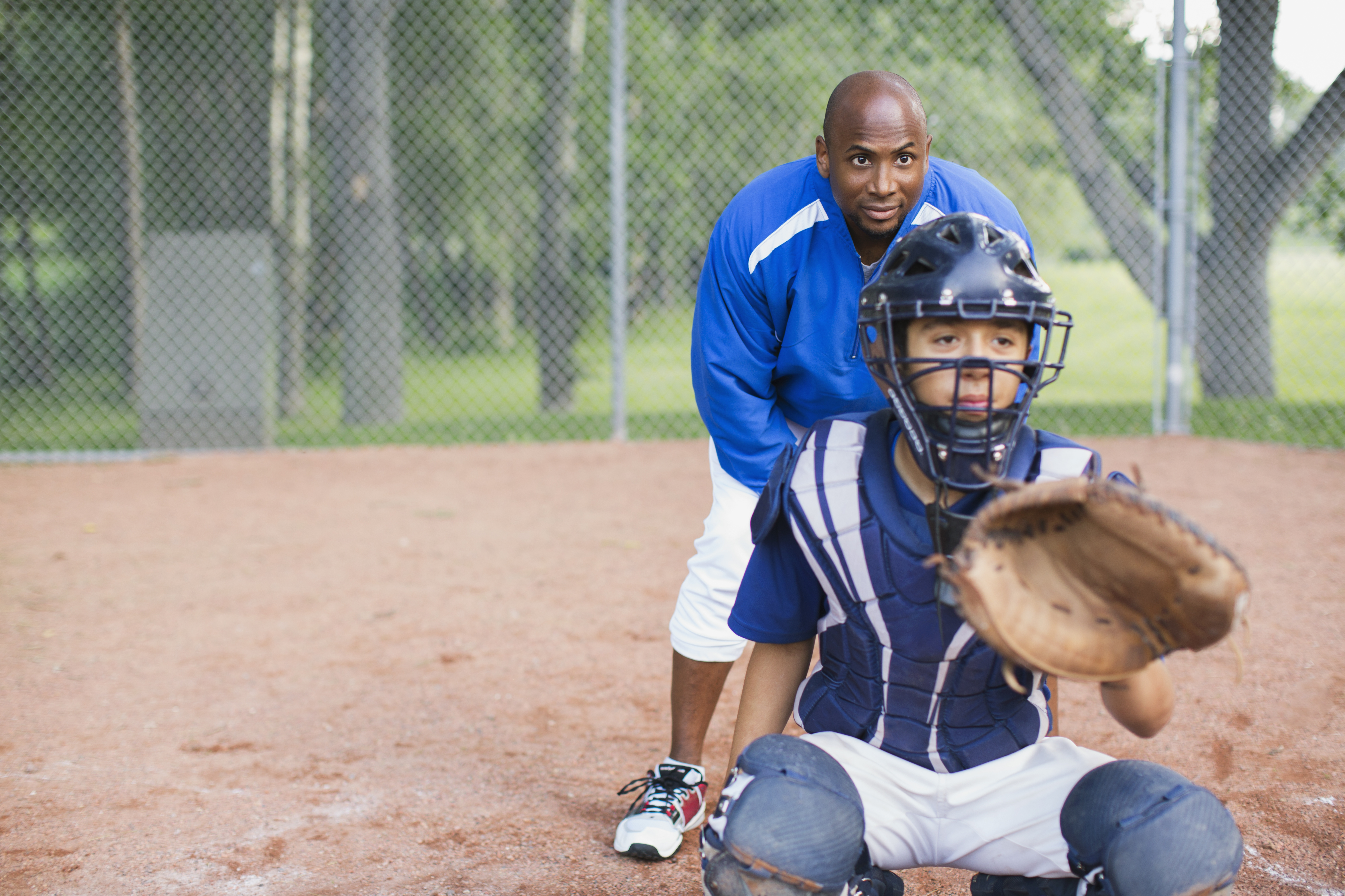 Child and coach playing baseball