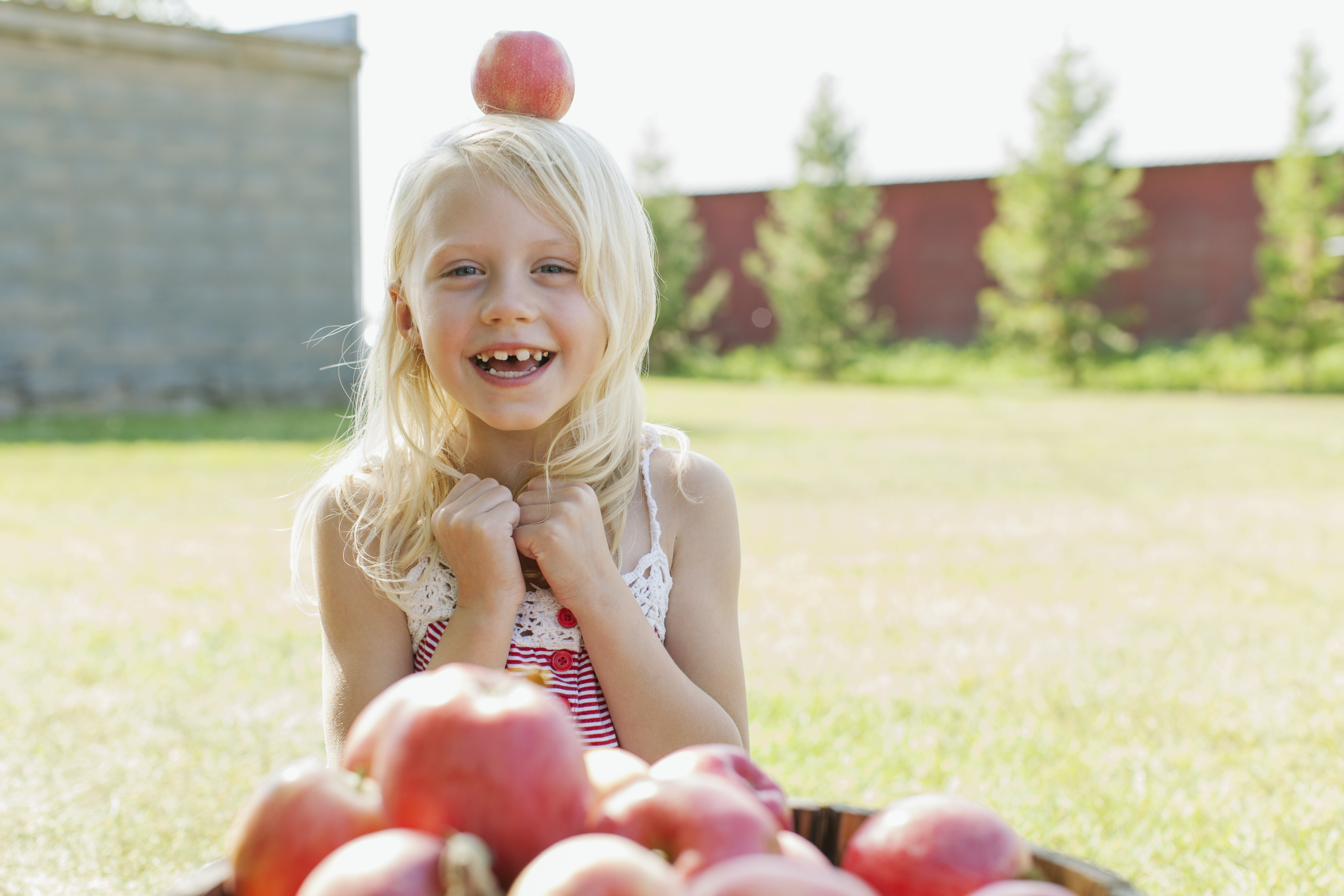 Little girl with an apple on her head