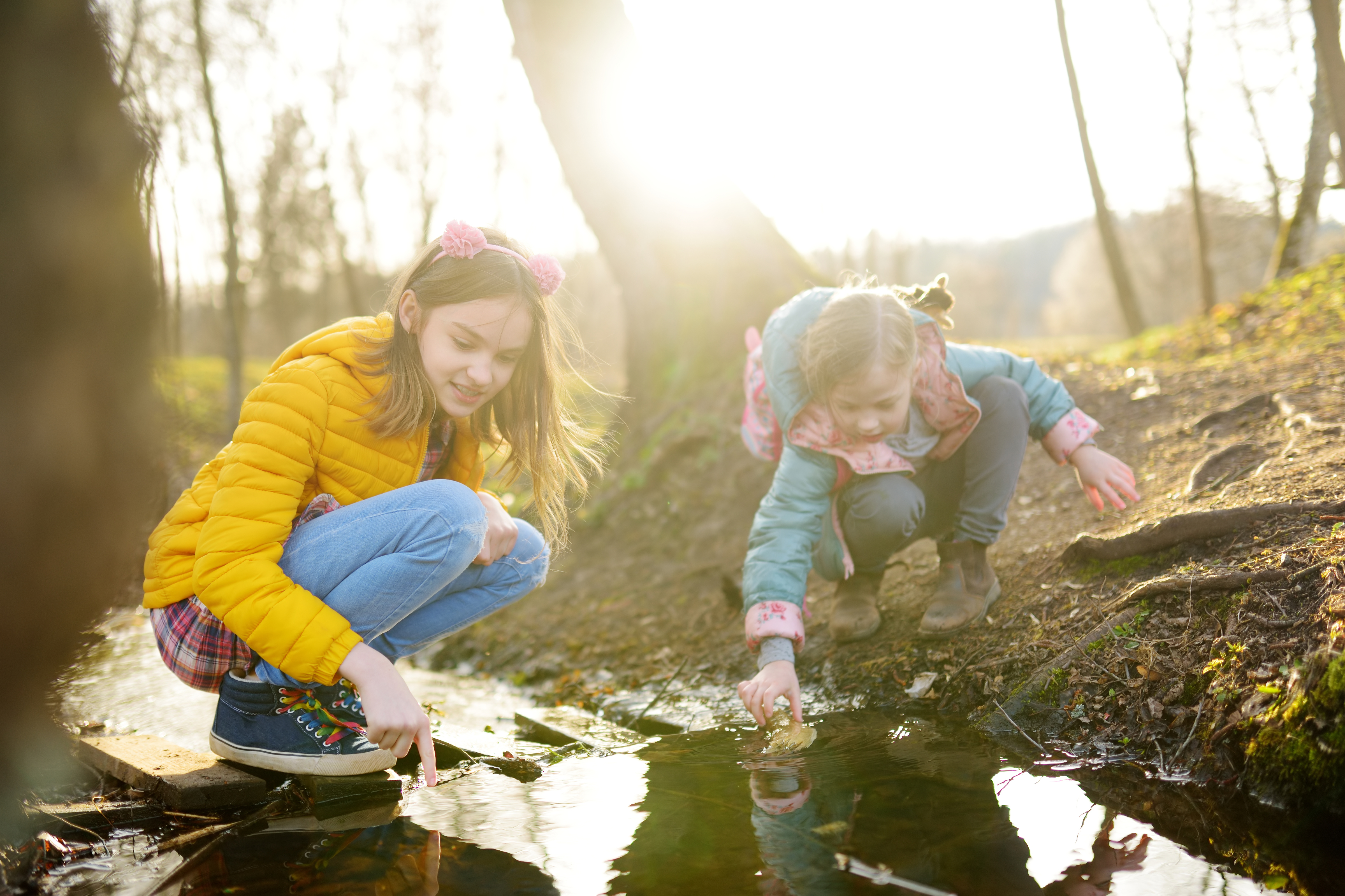 Two young kids play in a creek together