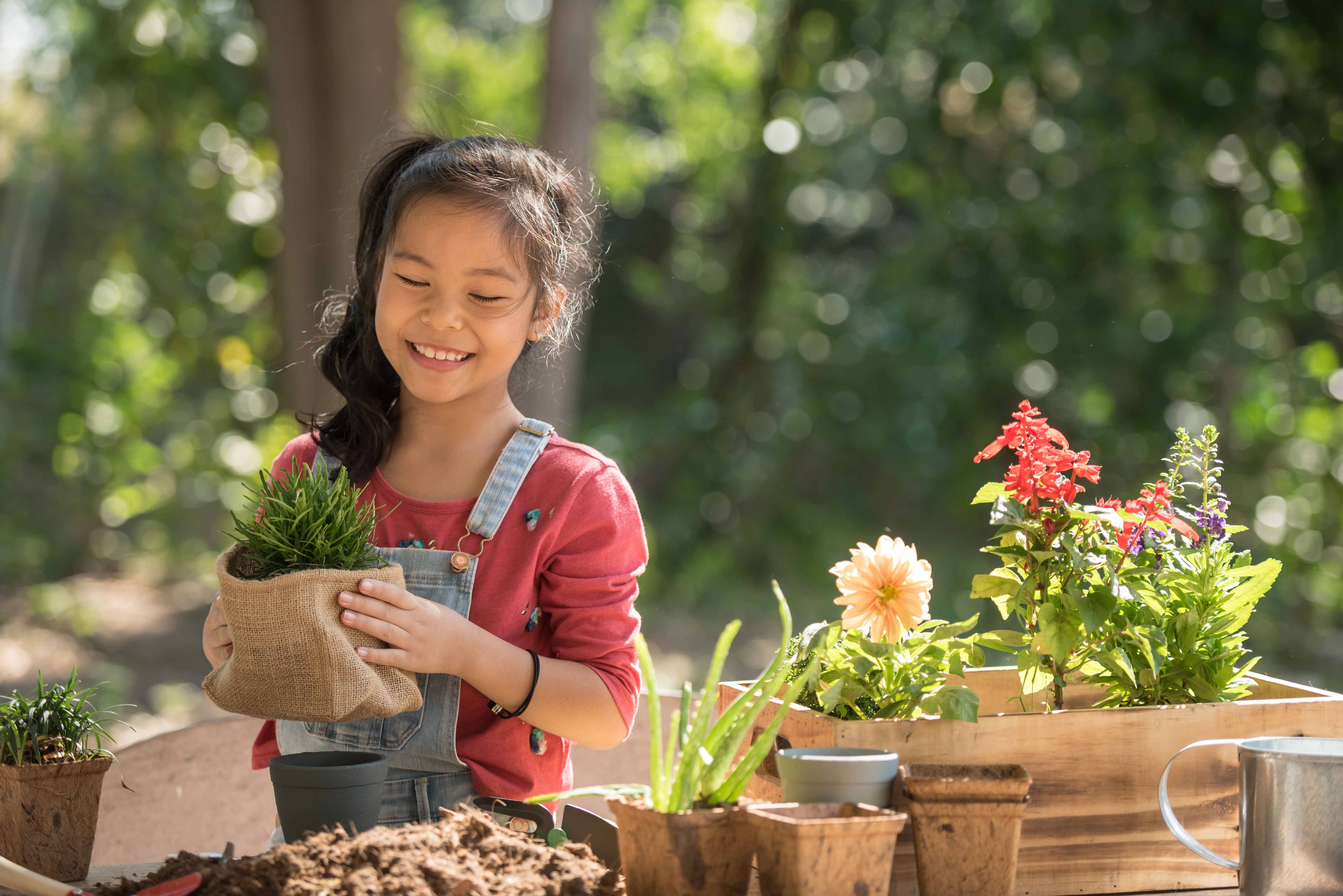 a girl holds a plant and smiles