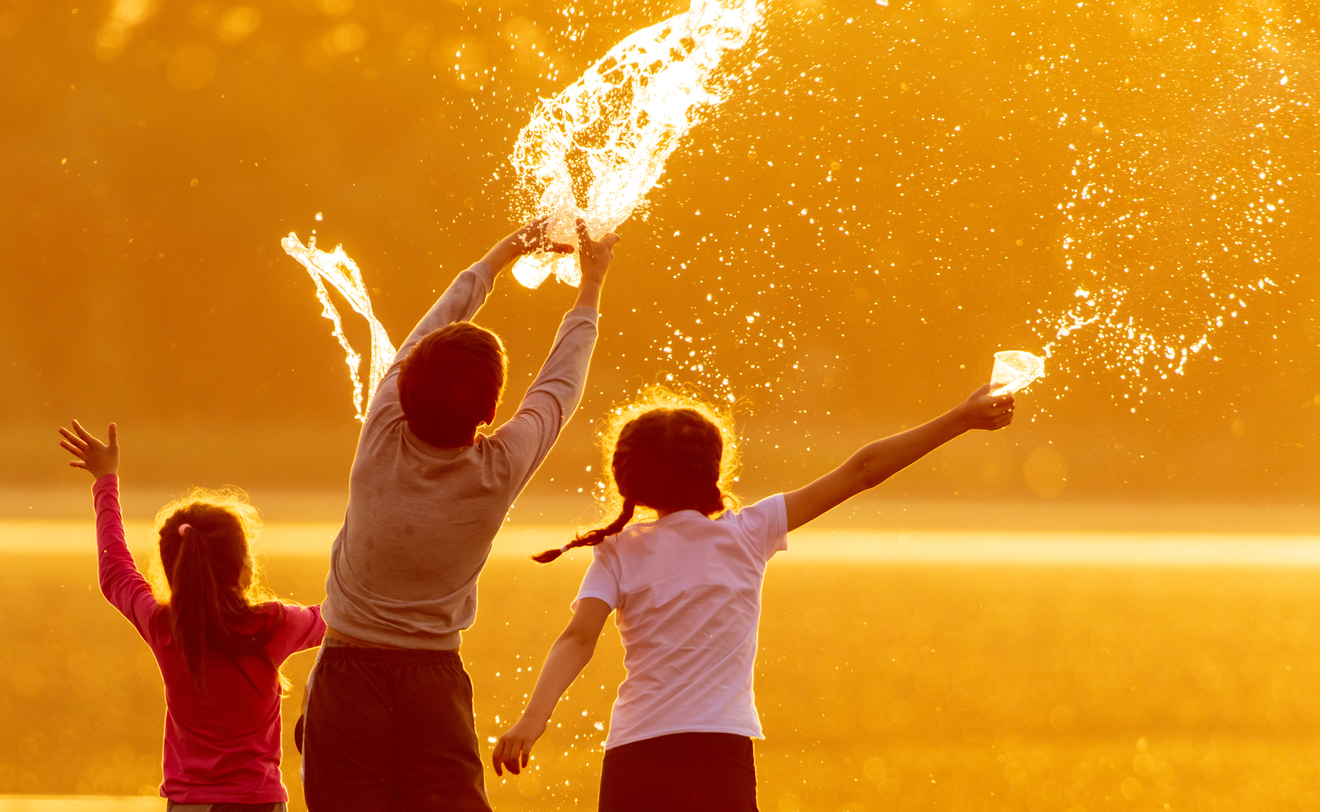 kids throw water while playing outside