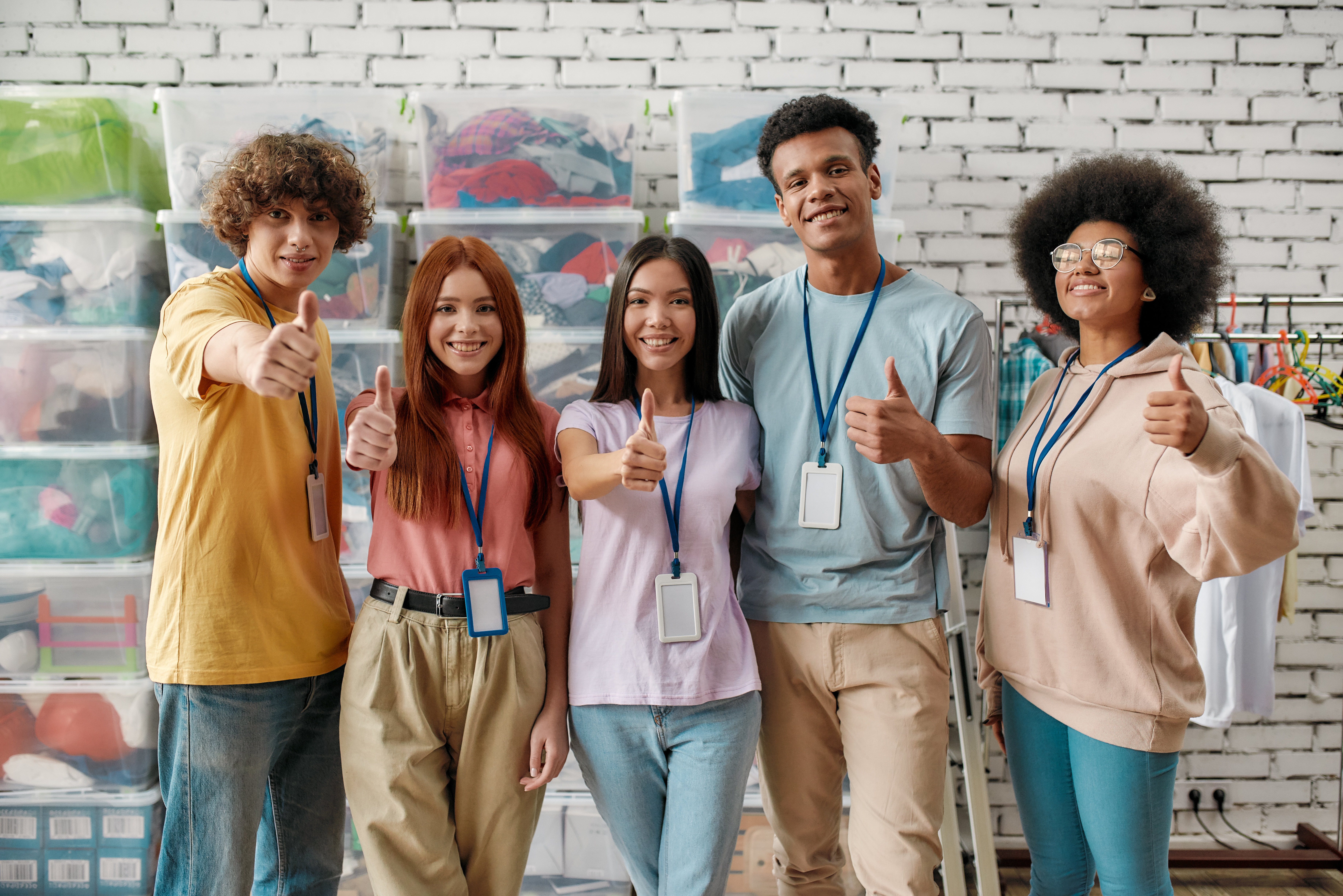 A group of people stand with their thumbs up