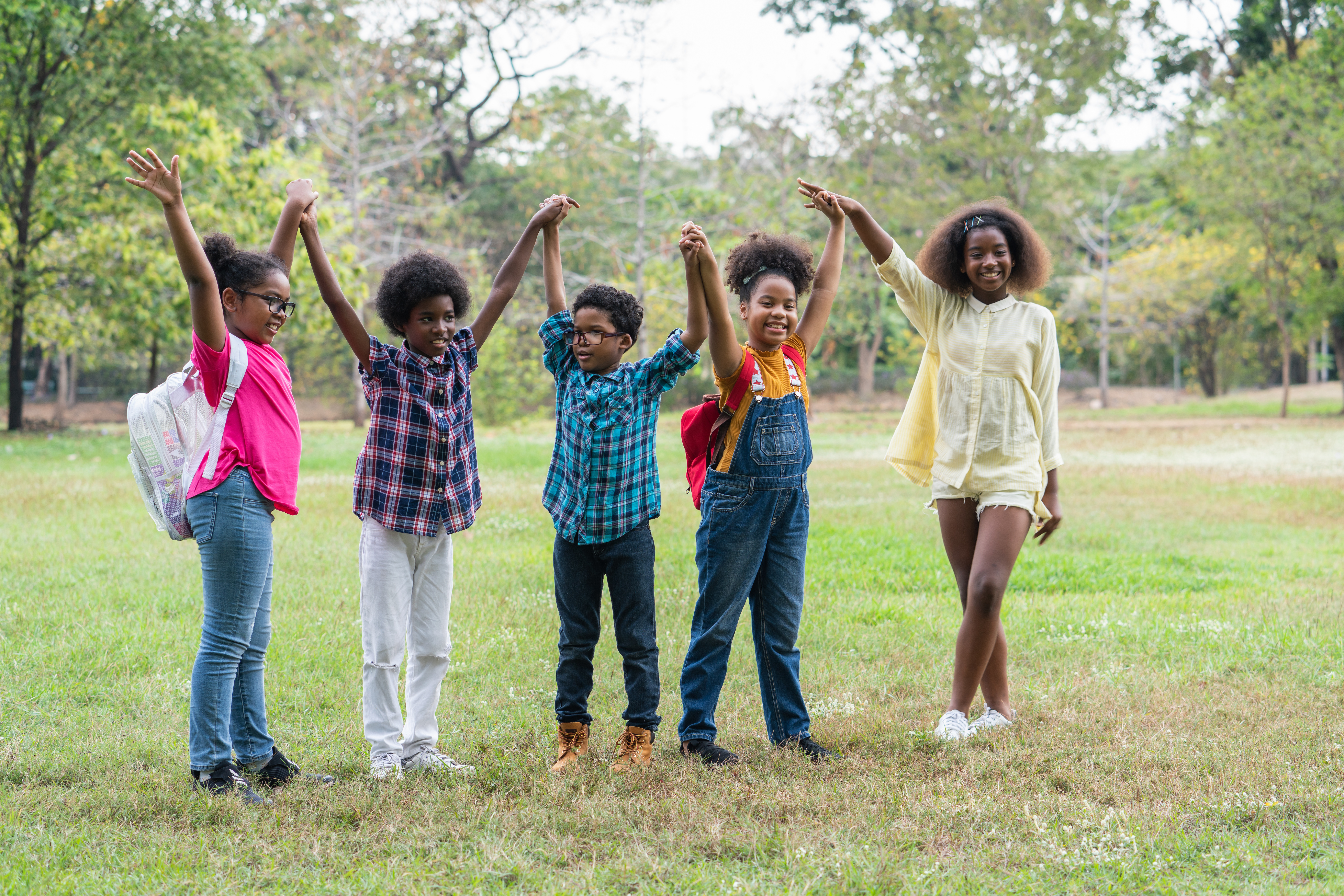 Young people raise their arms up and hold hands