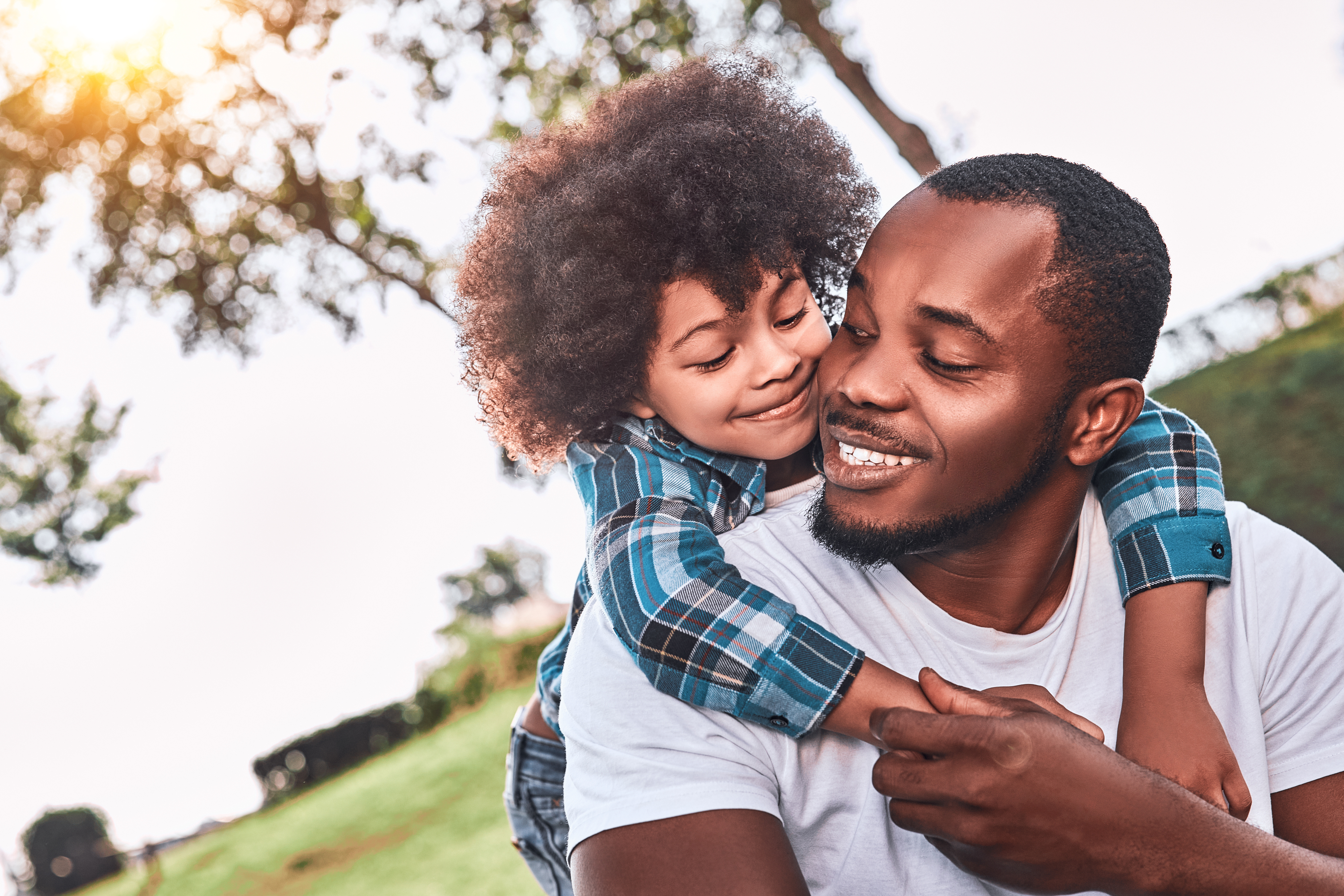 father and child hug in a park