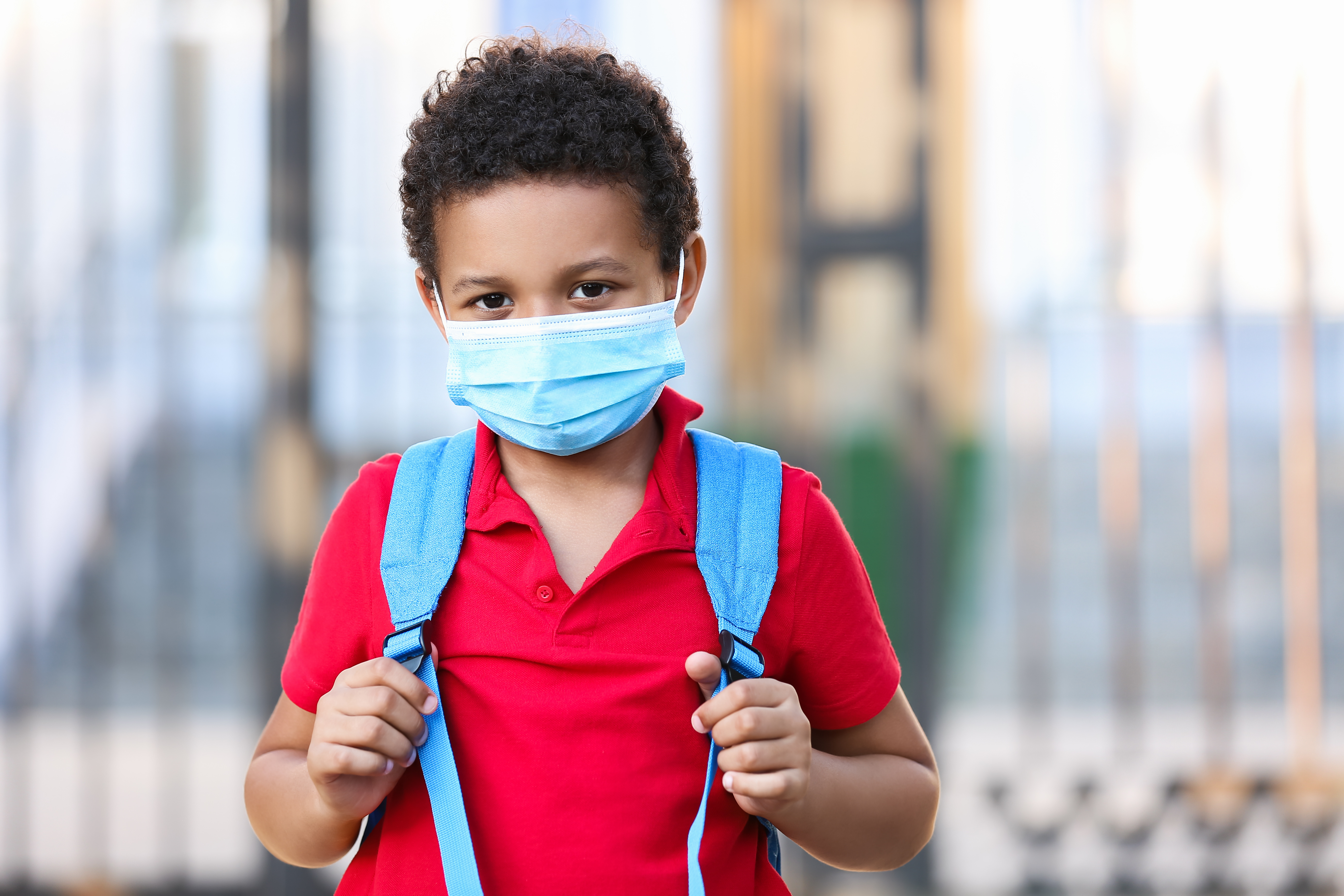 A child goes to school wearing a mask