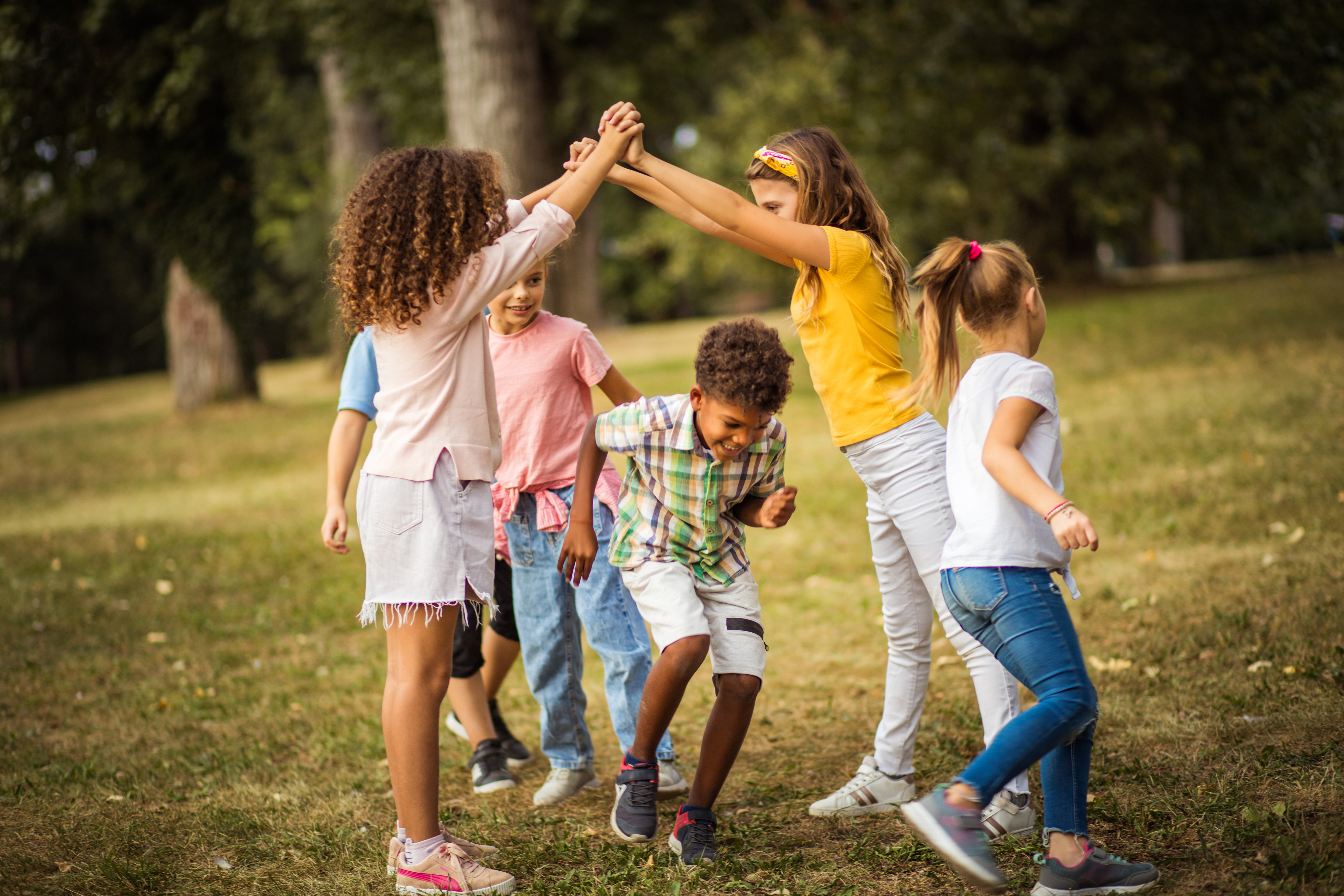 A group of children play on a green lawn