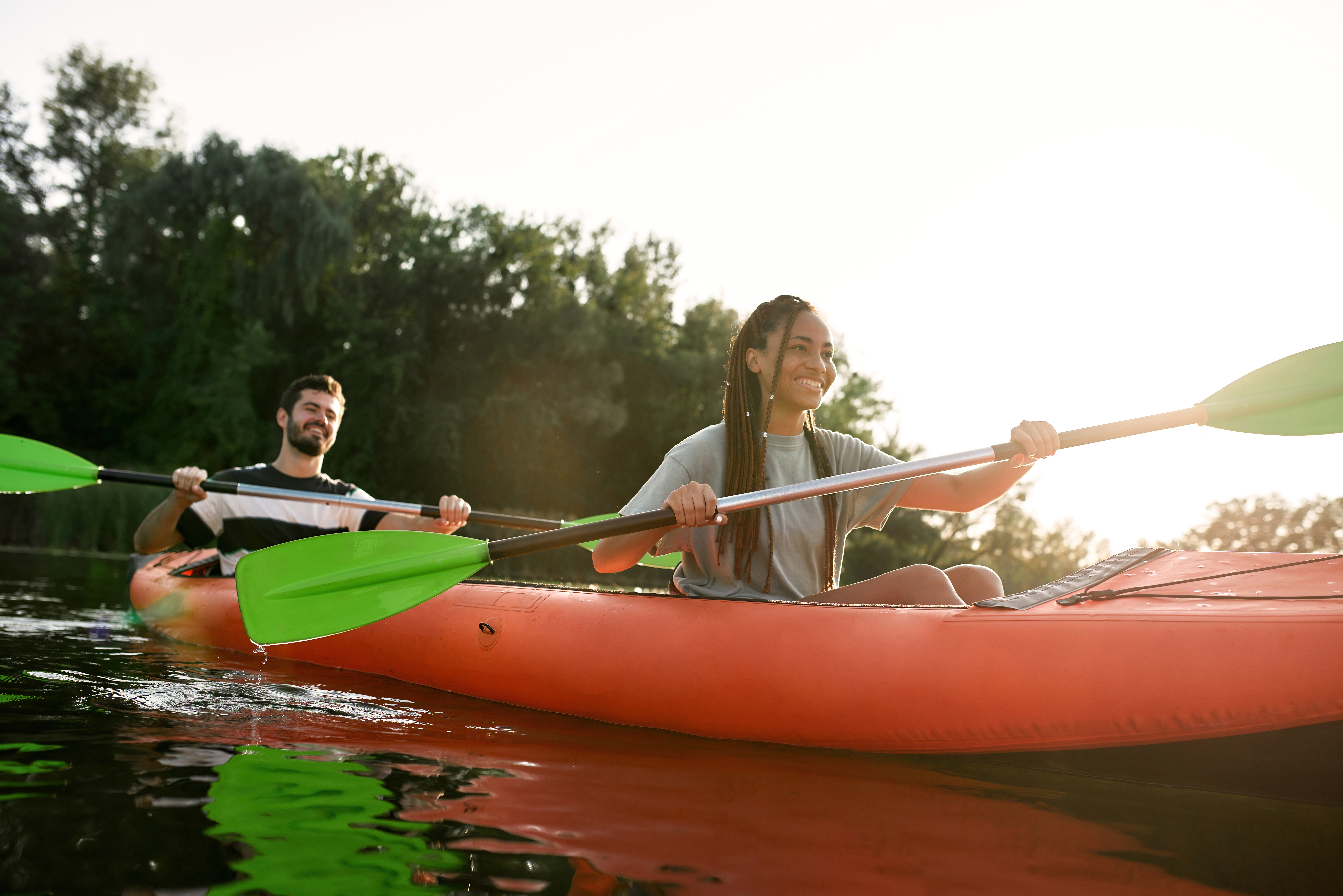 Two people kayak together on a lake.