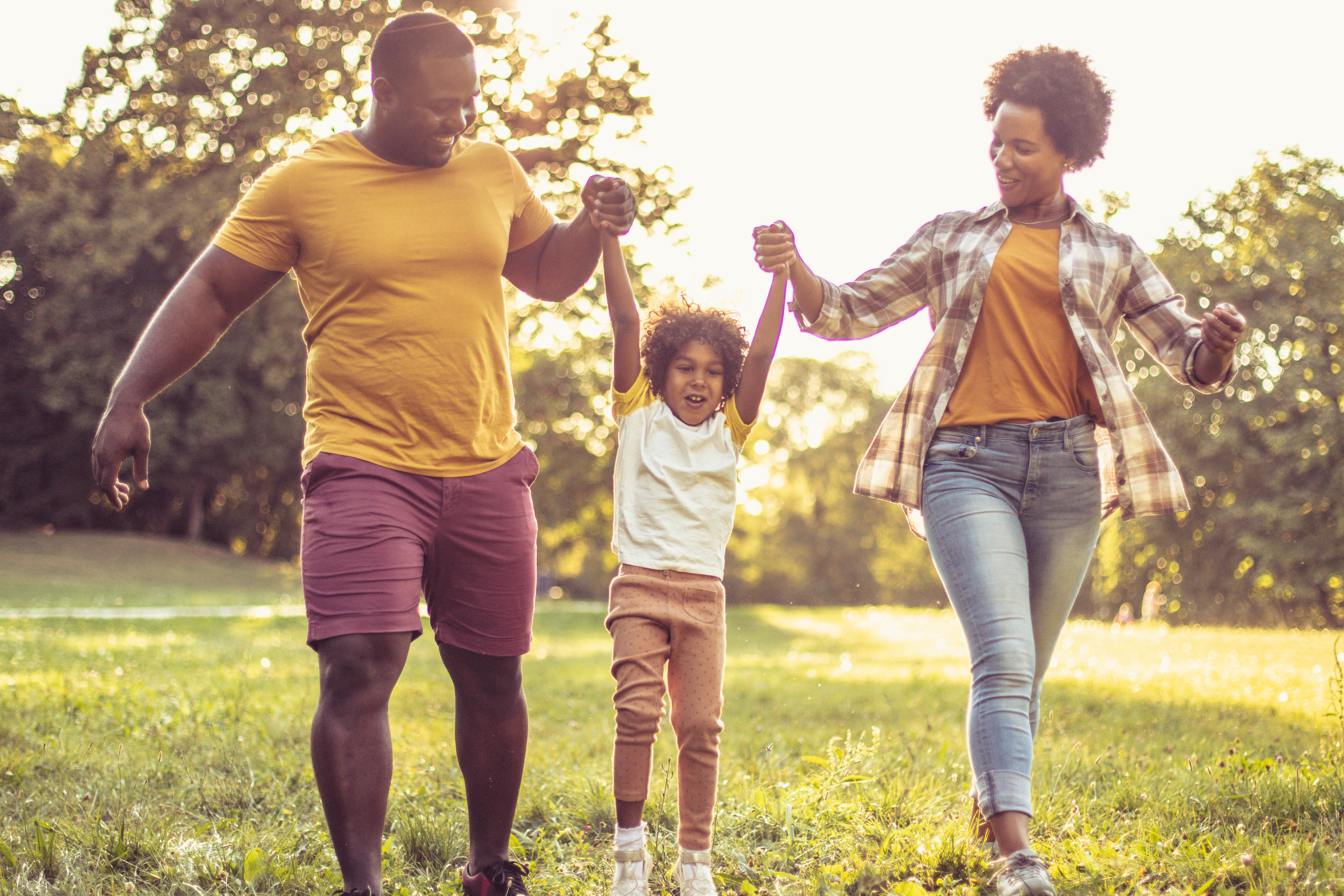 A family walks across a green lawn