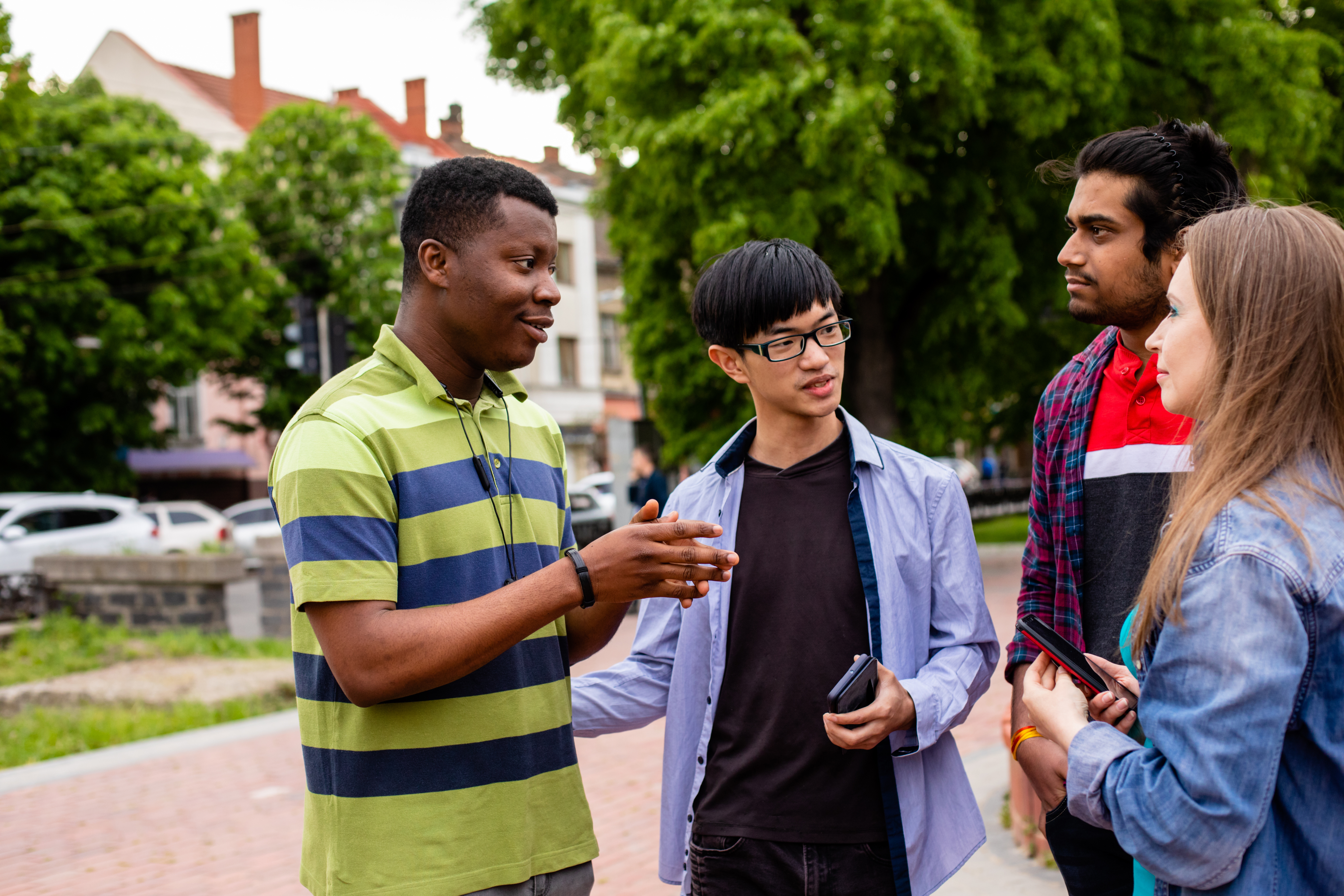 College students stand and talk on a sidewalk