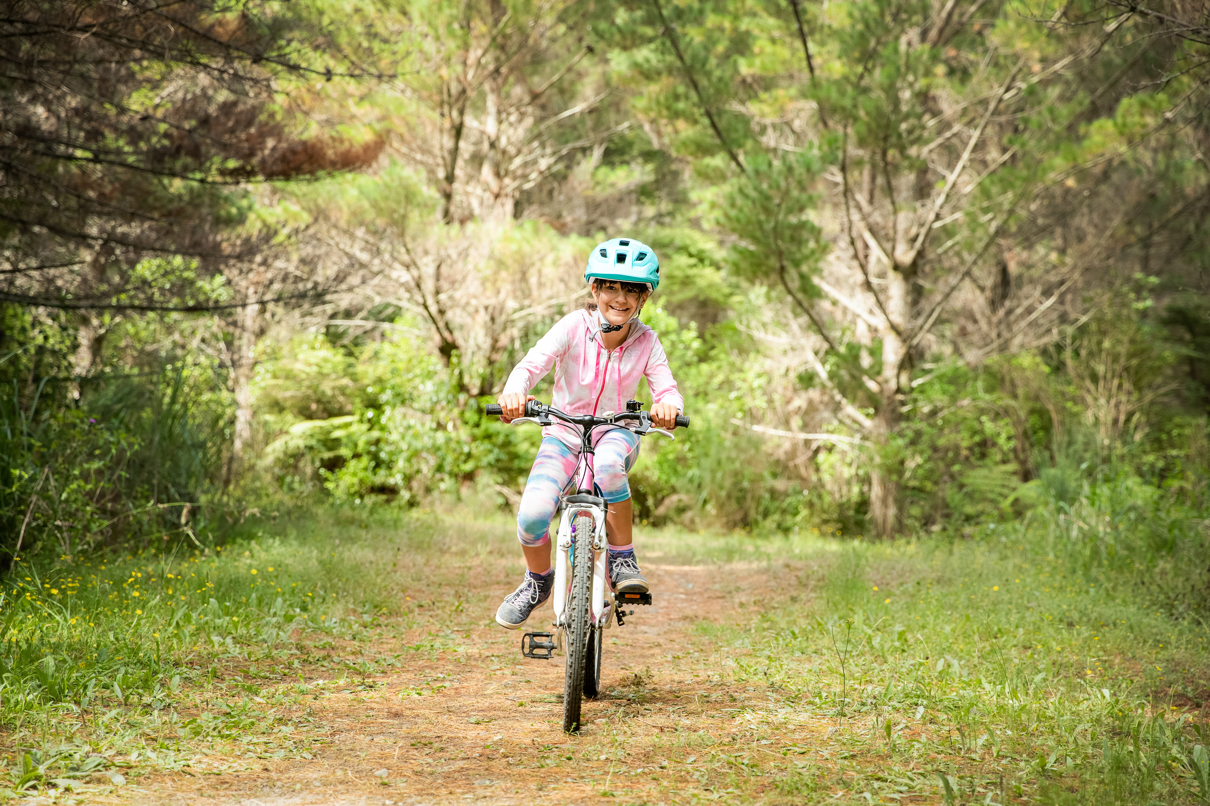 A girl rides her bike through the woods