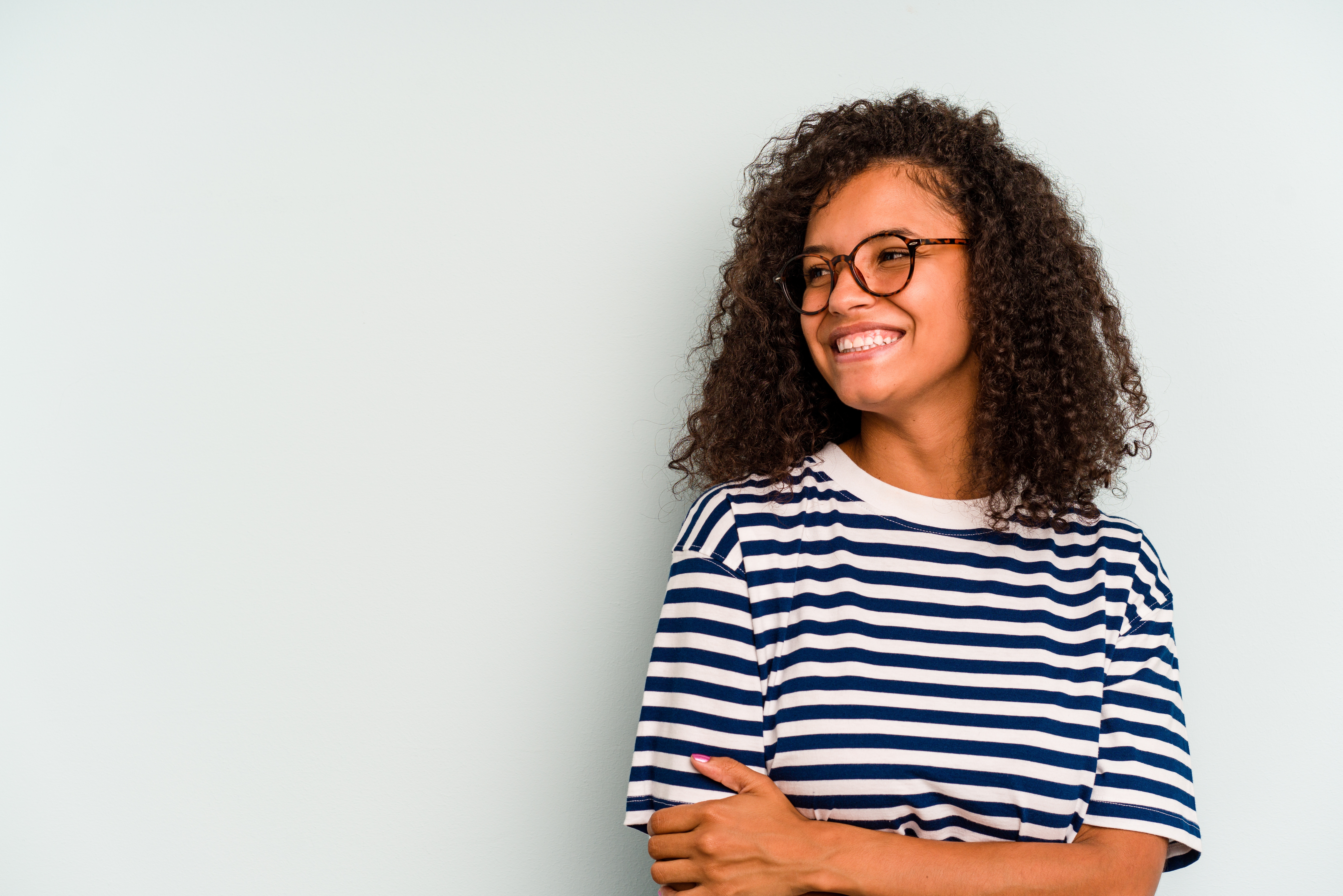 A young person looks to their side and smiles