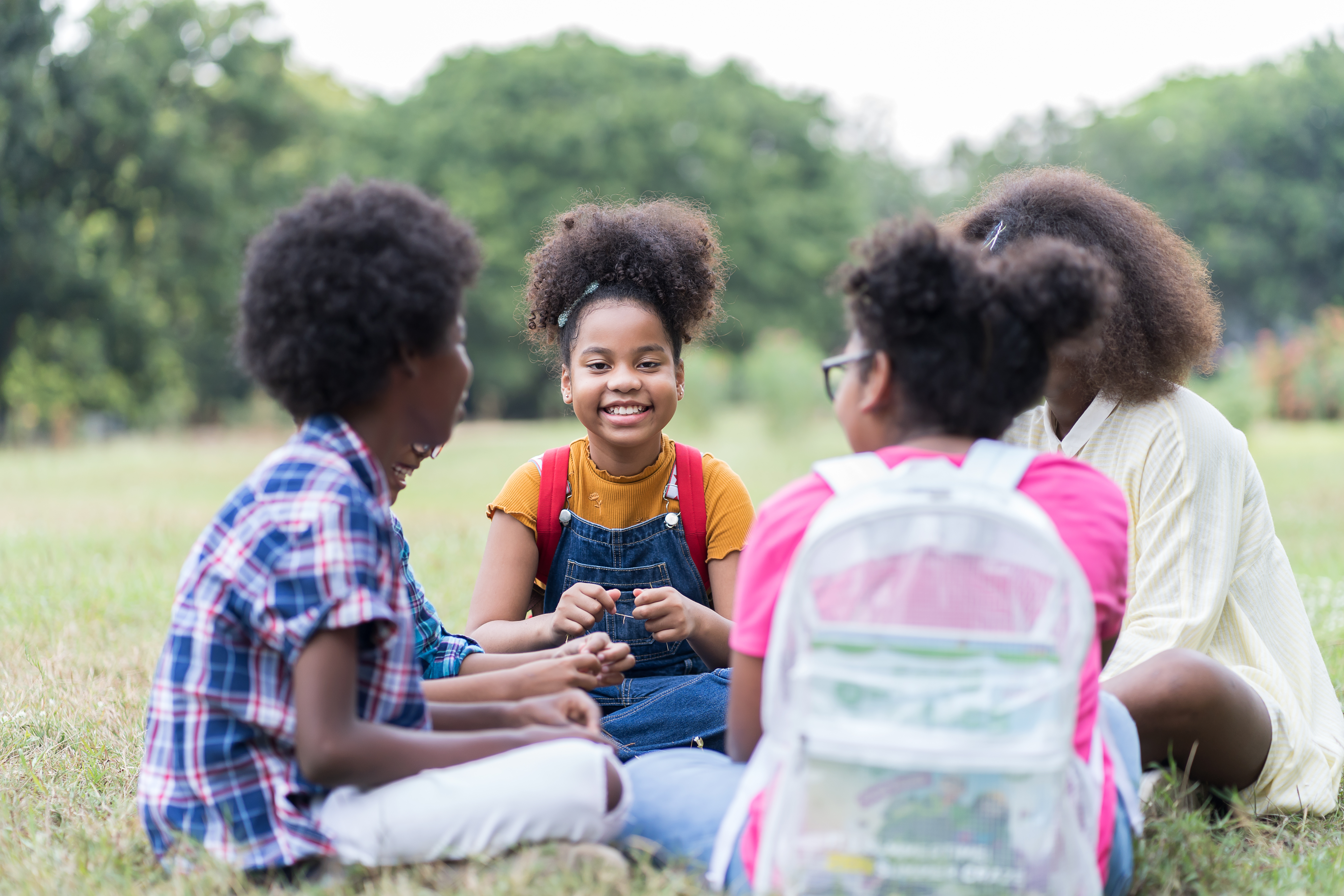 young people sit in a circle outside