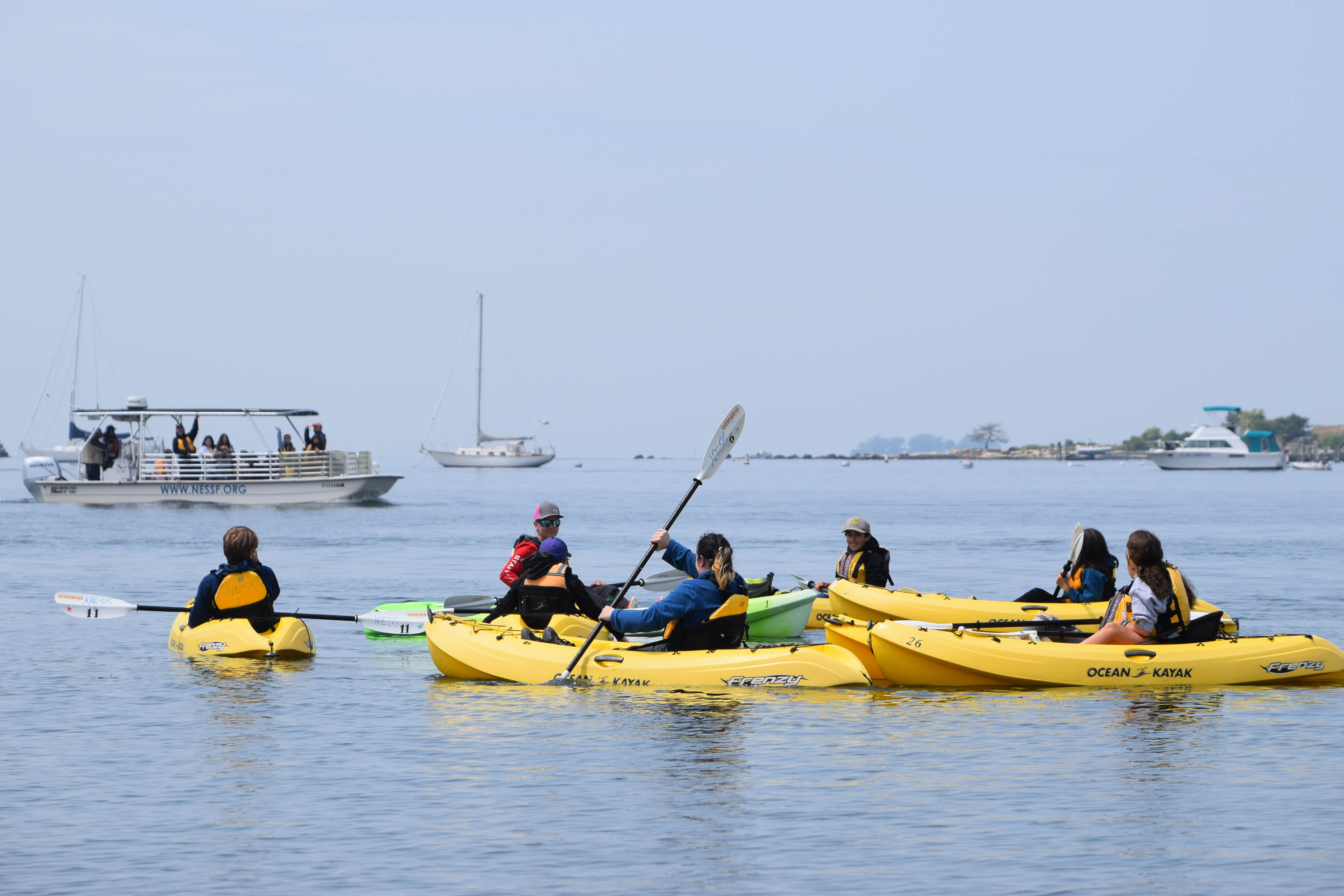 a group kayaks on the ocean in yellow boats