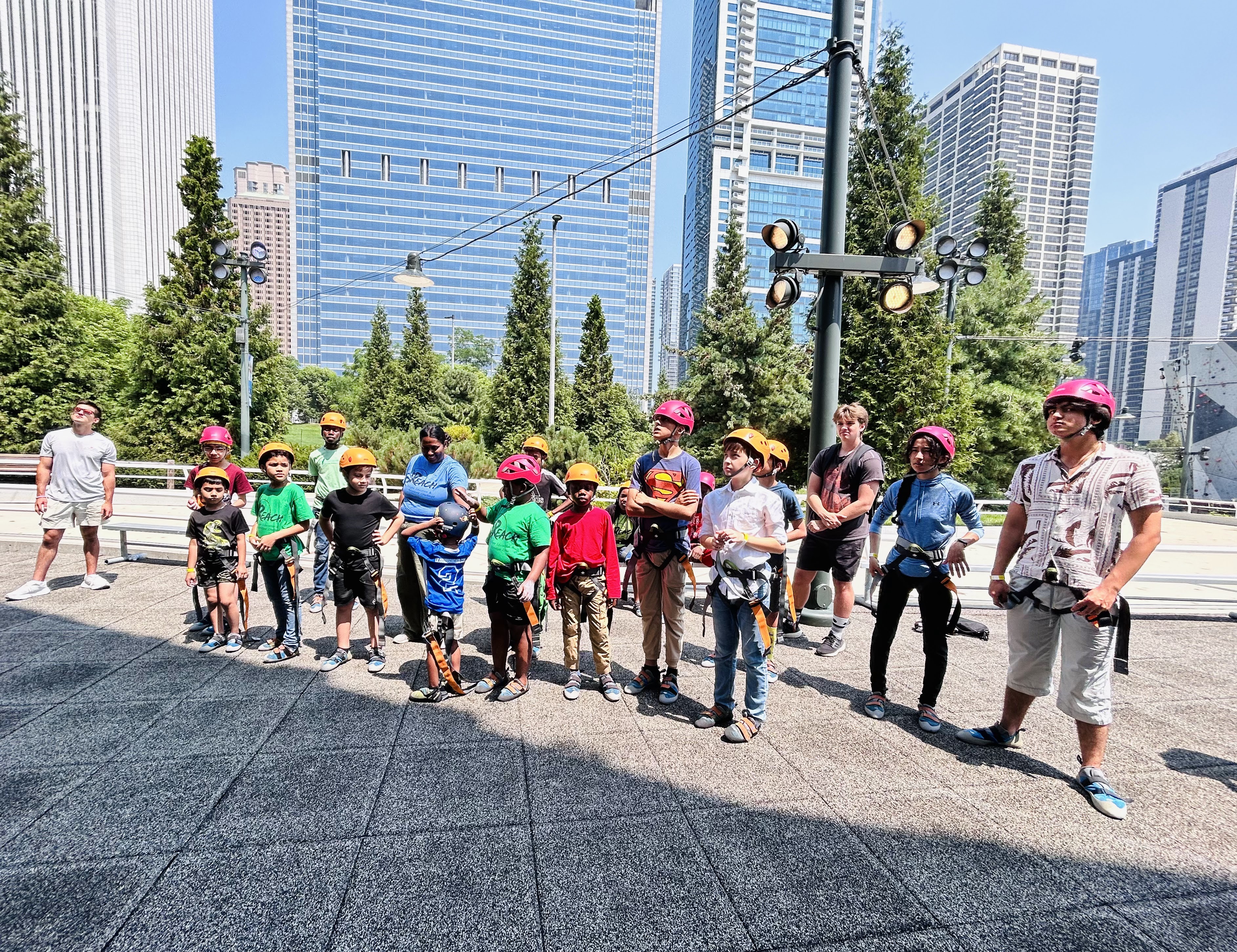 a large group stands in climbing equipment in an urban setting