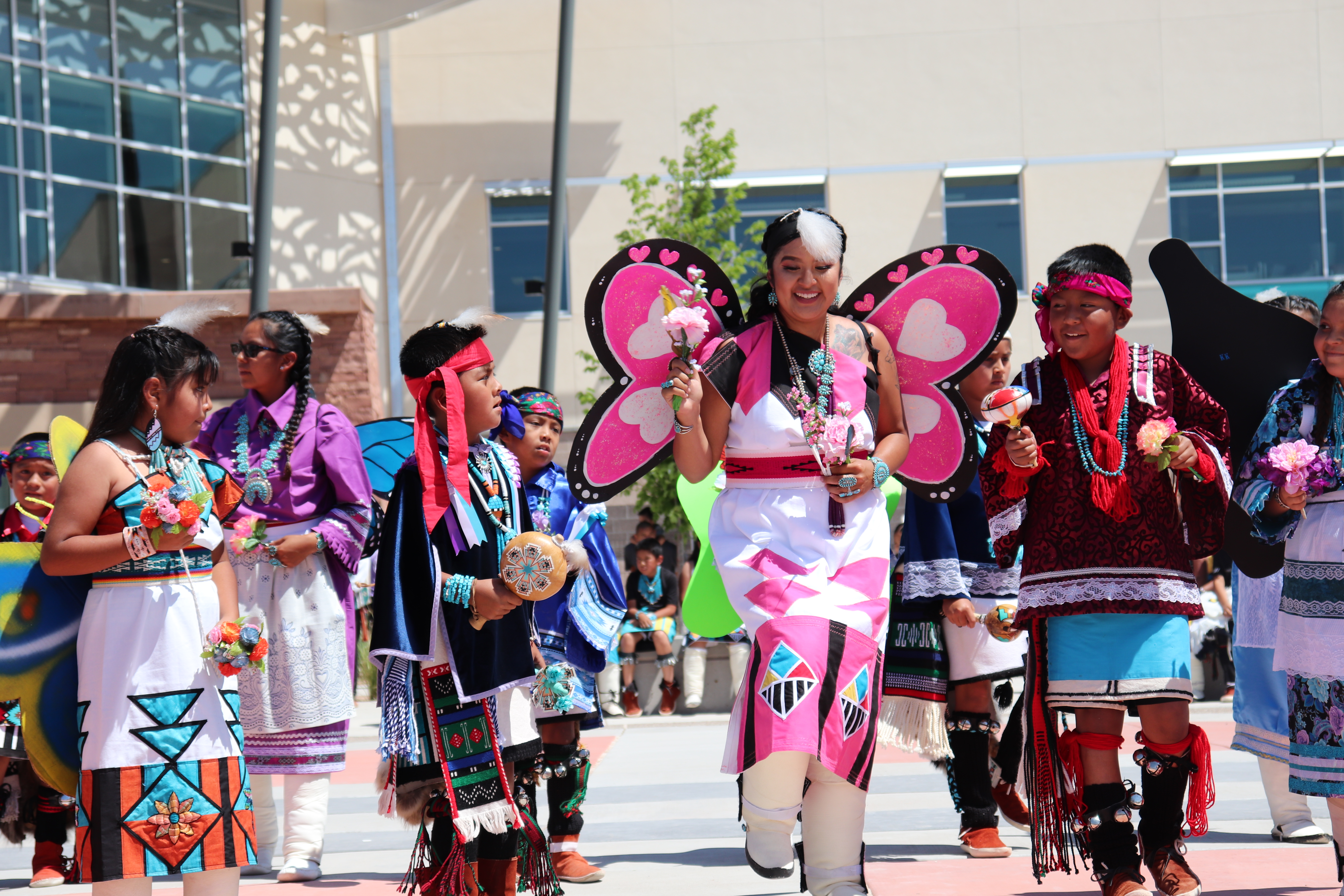 several people walk forwards toward the camera dressed in colorful clothing