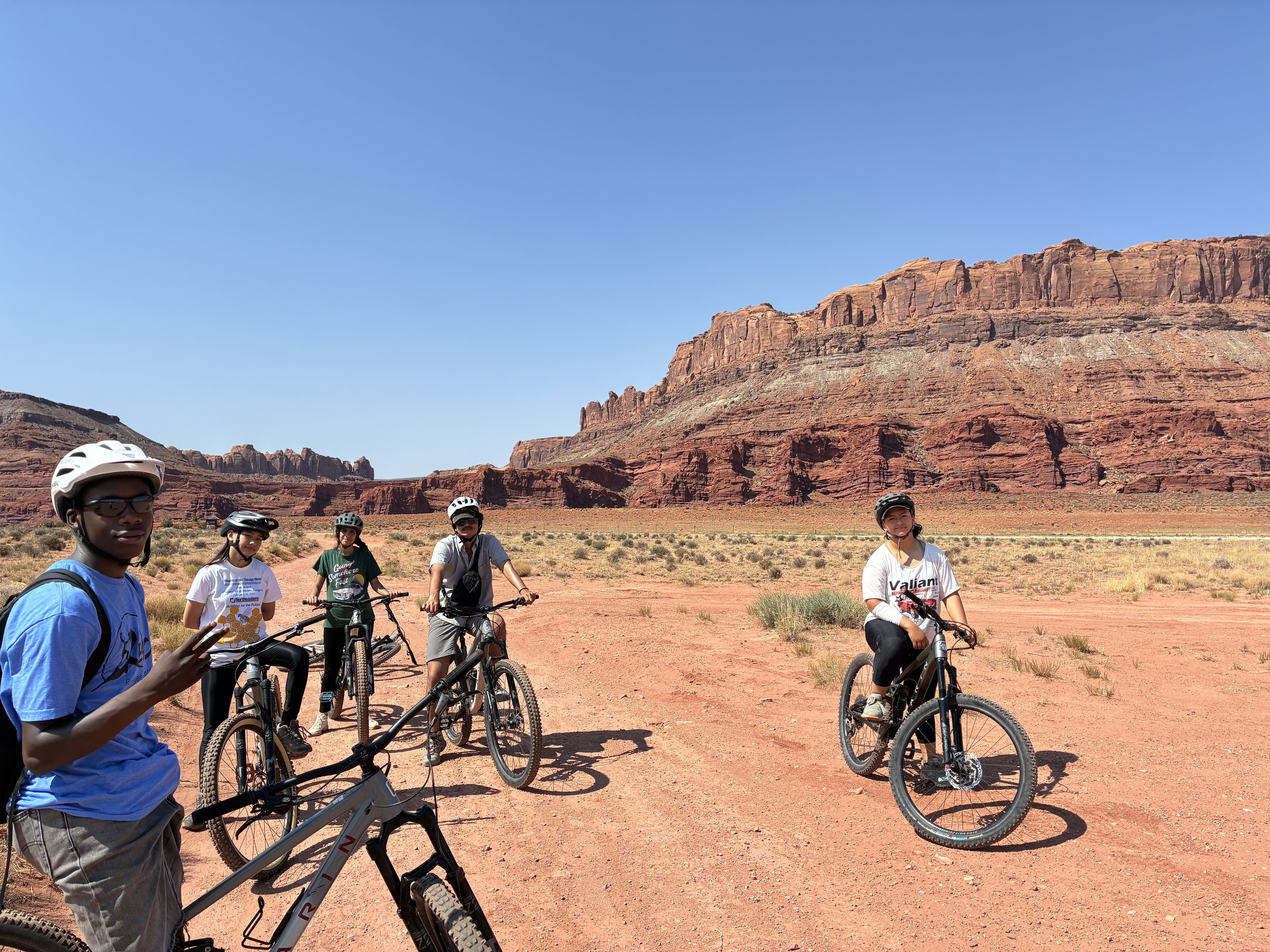 A group of teens mountain bike in a desert