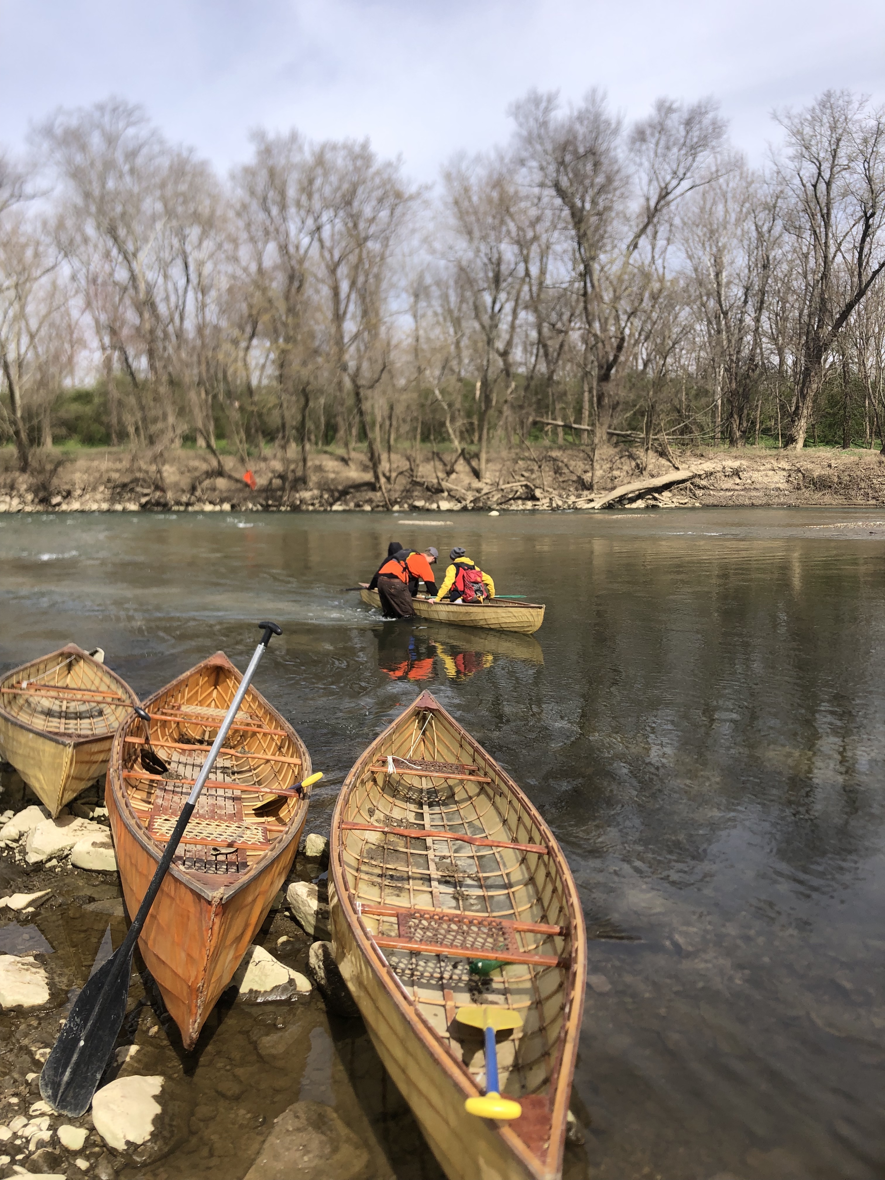 Canoes rest by the side of a river in winter