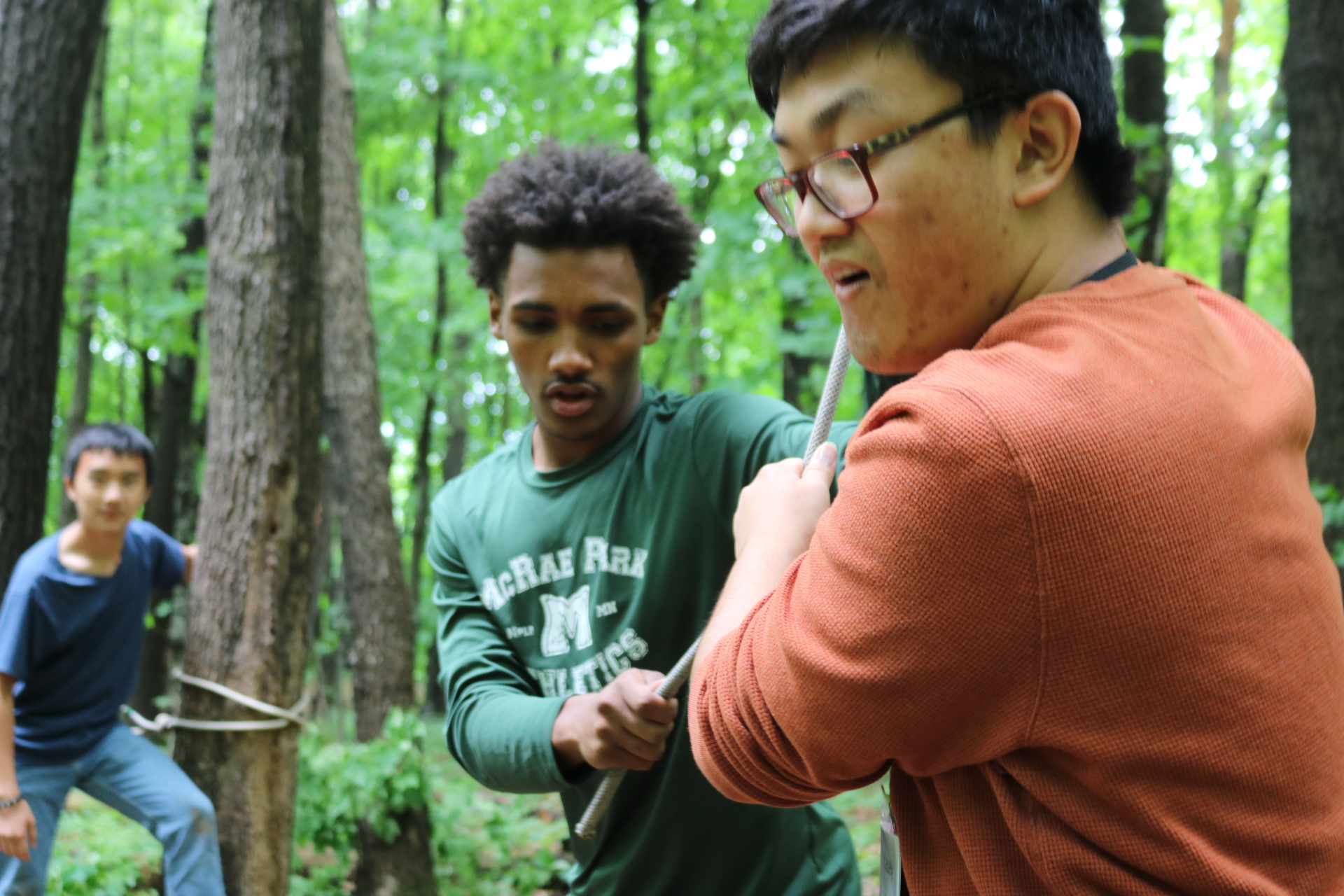 several young people work together on a ropes course