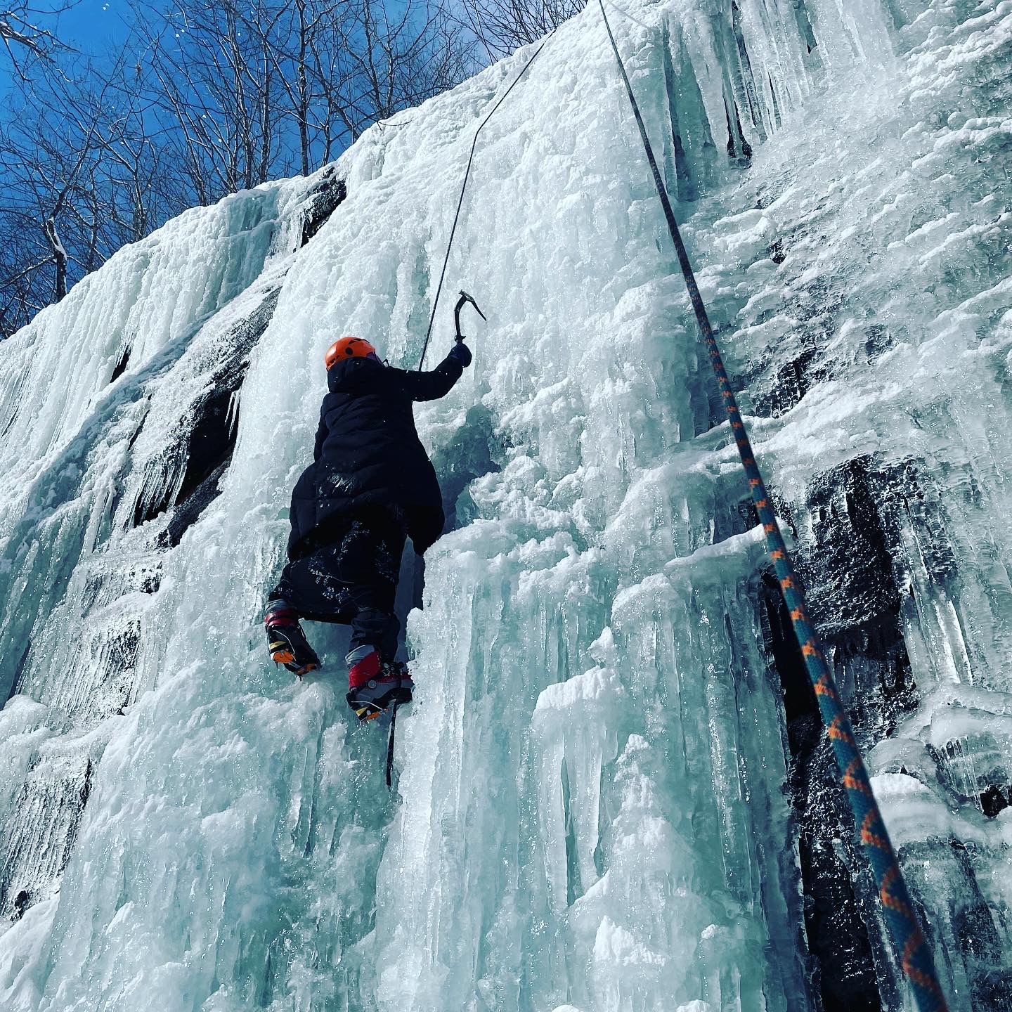 a student ice climbs