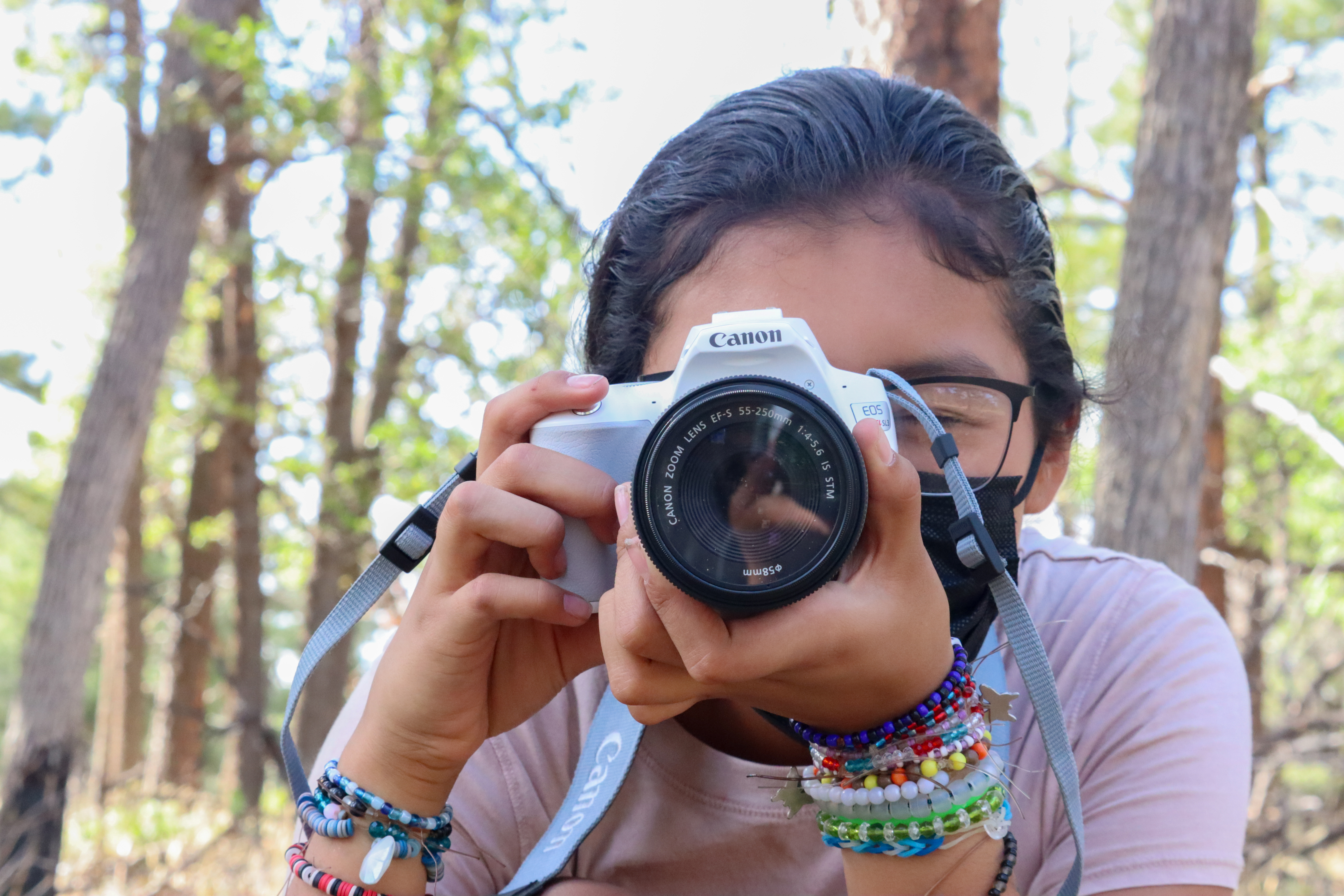 a child leans in while holding a camera up to their eye