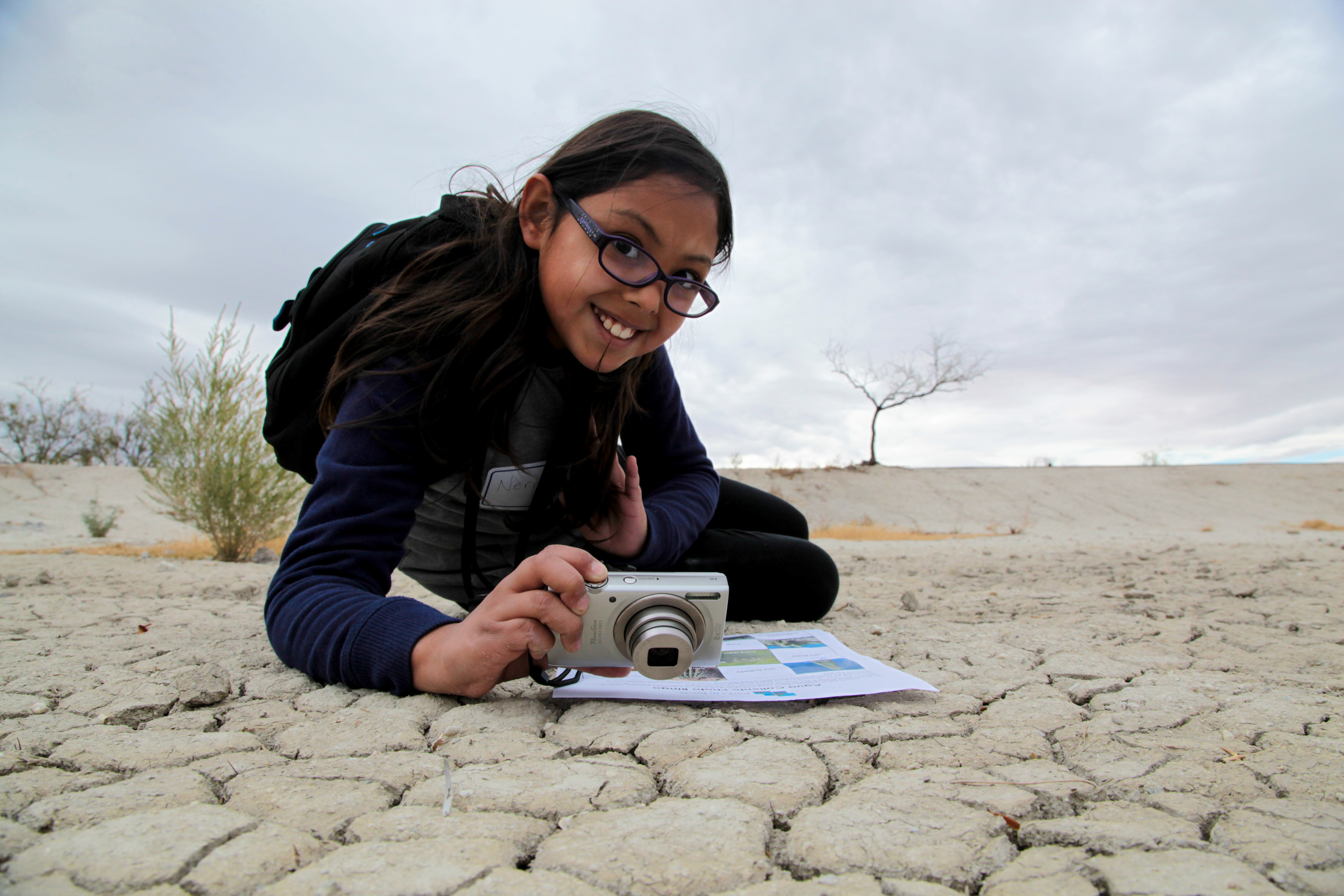 a child lays on the ground to take a photo