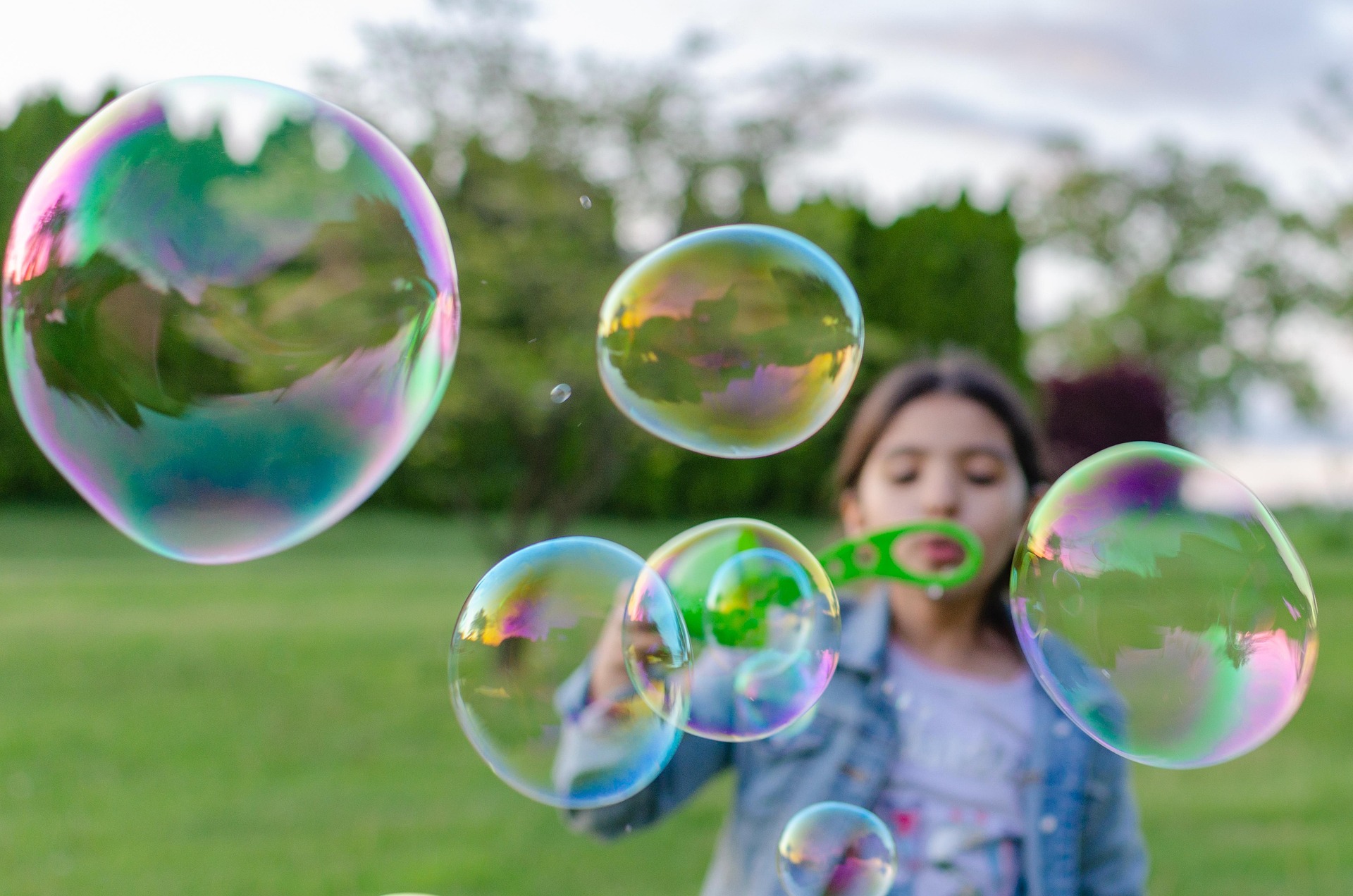 a girl blows bubbles outside